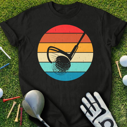 Black t-shirt with golf club and ball graphic against a retro sunset background.