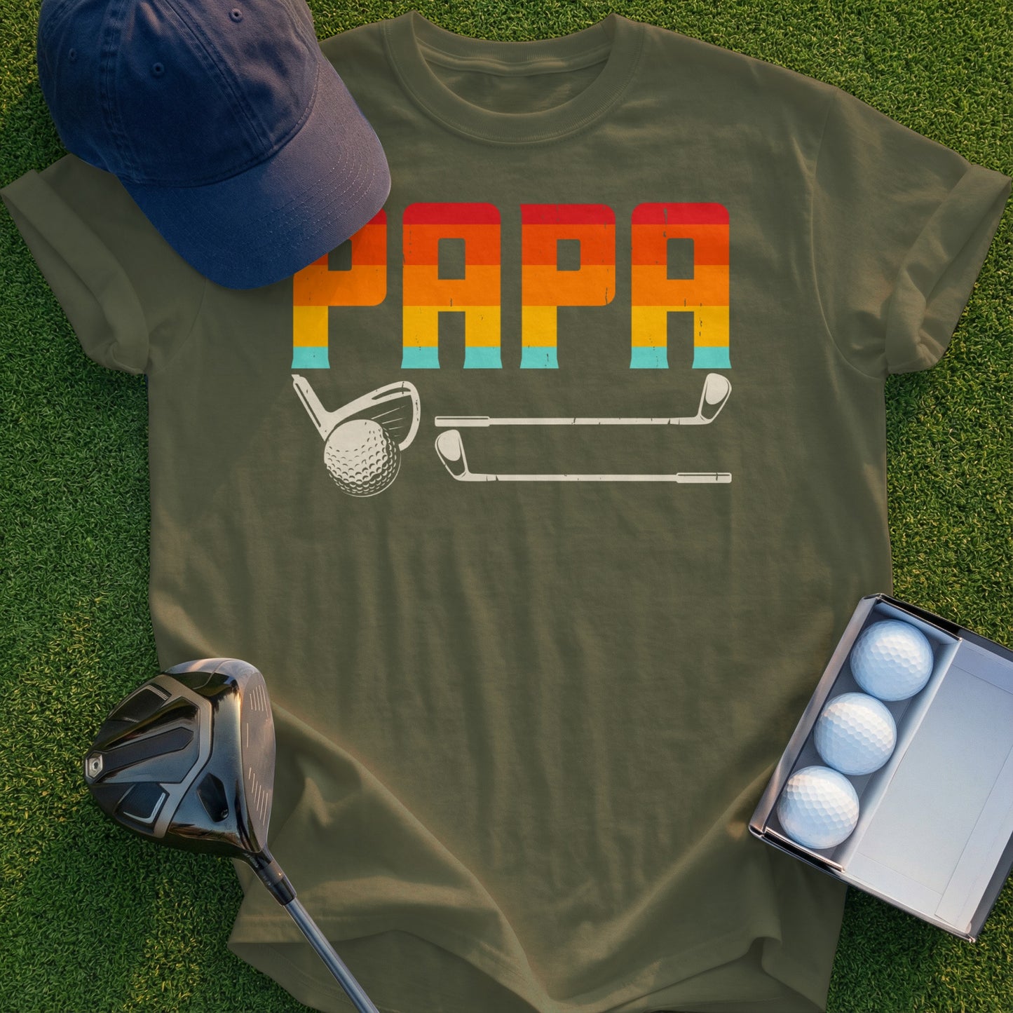 Olive green t-shirt with "PAPA" in colorful striped font, golf club, and golf balls.