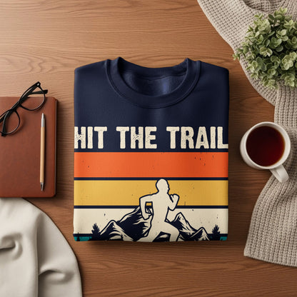 Navy sweatshirt with "HIT THE TRAIL" text above runner and mountain graphic.