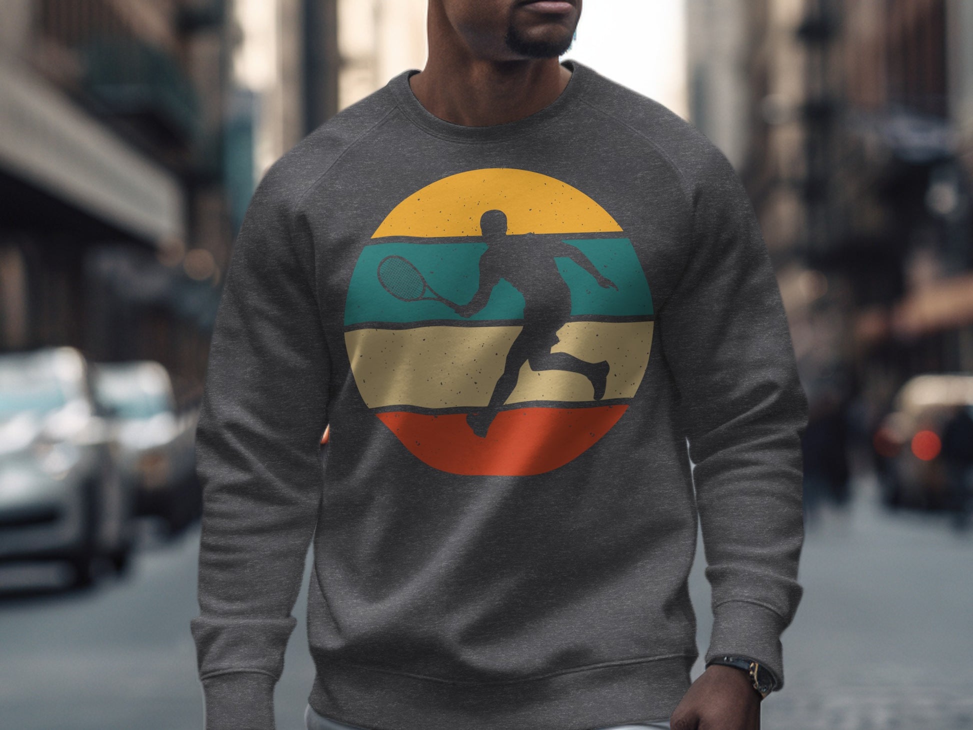 Man wearing a grey crewneck sweatshirt with a circular tennis player graphic.