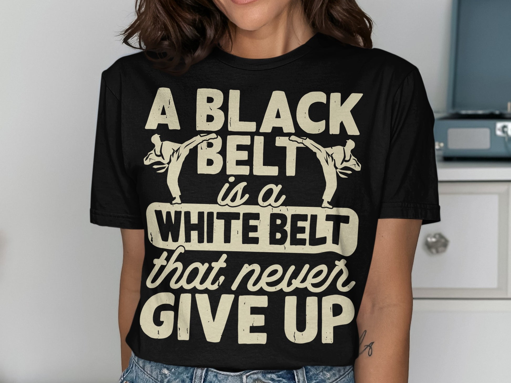 Black t-shirt with text "A BLACK BELT is a WHITE BELT that never GIVE UP".