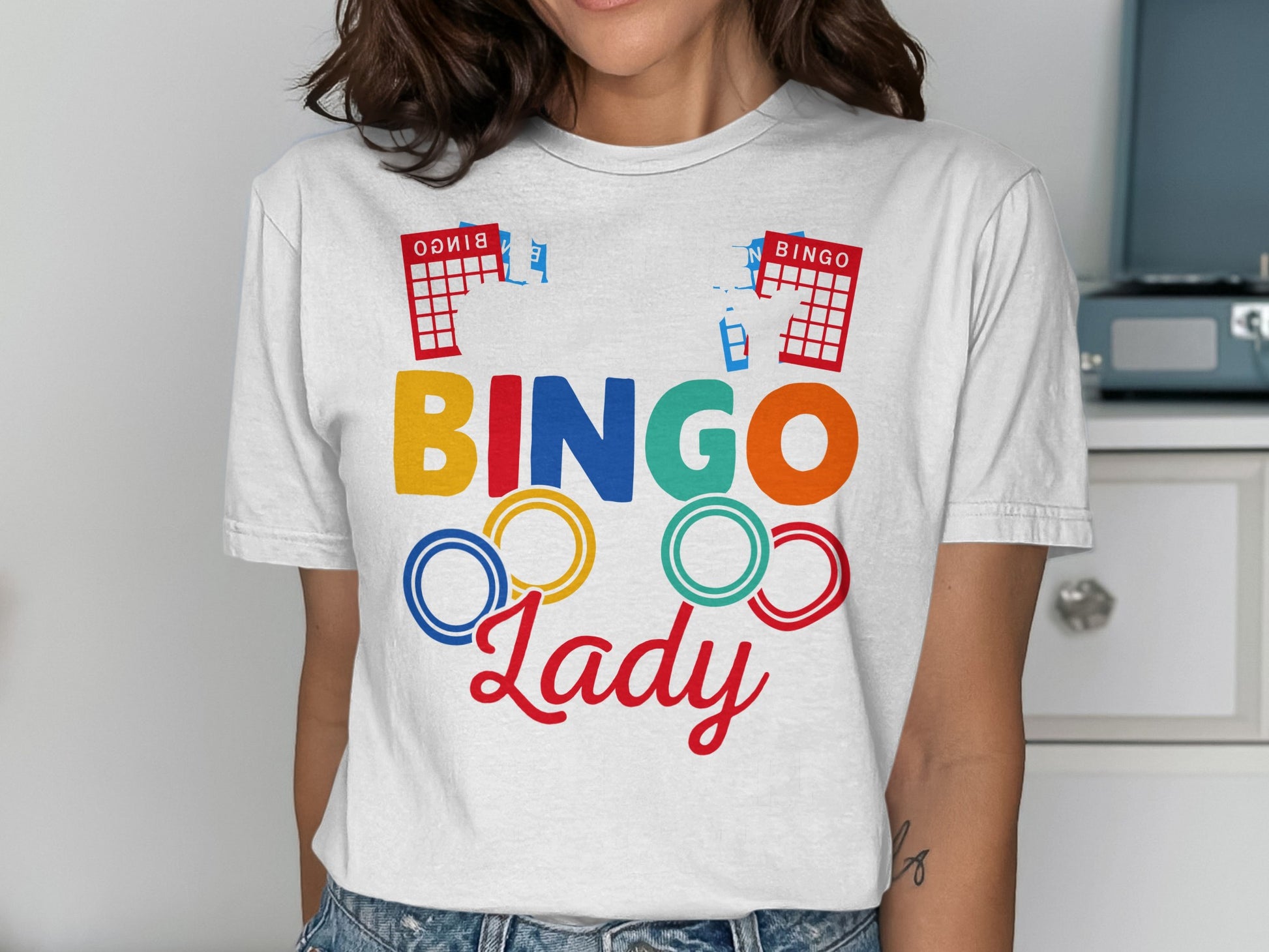 Woman wearing a white t-shirt with colorful "BINGO Lady" text and bingo cards.