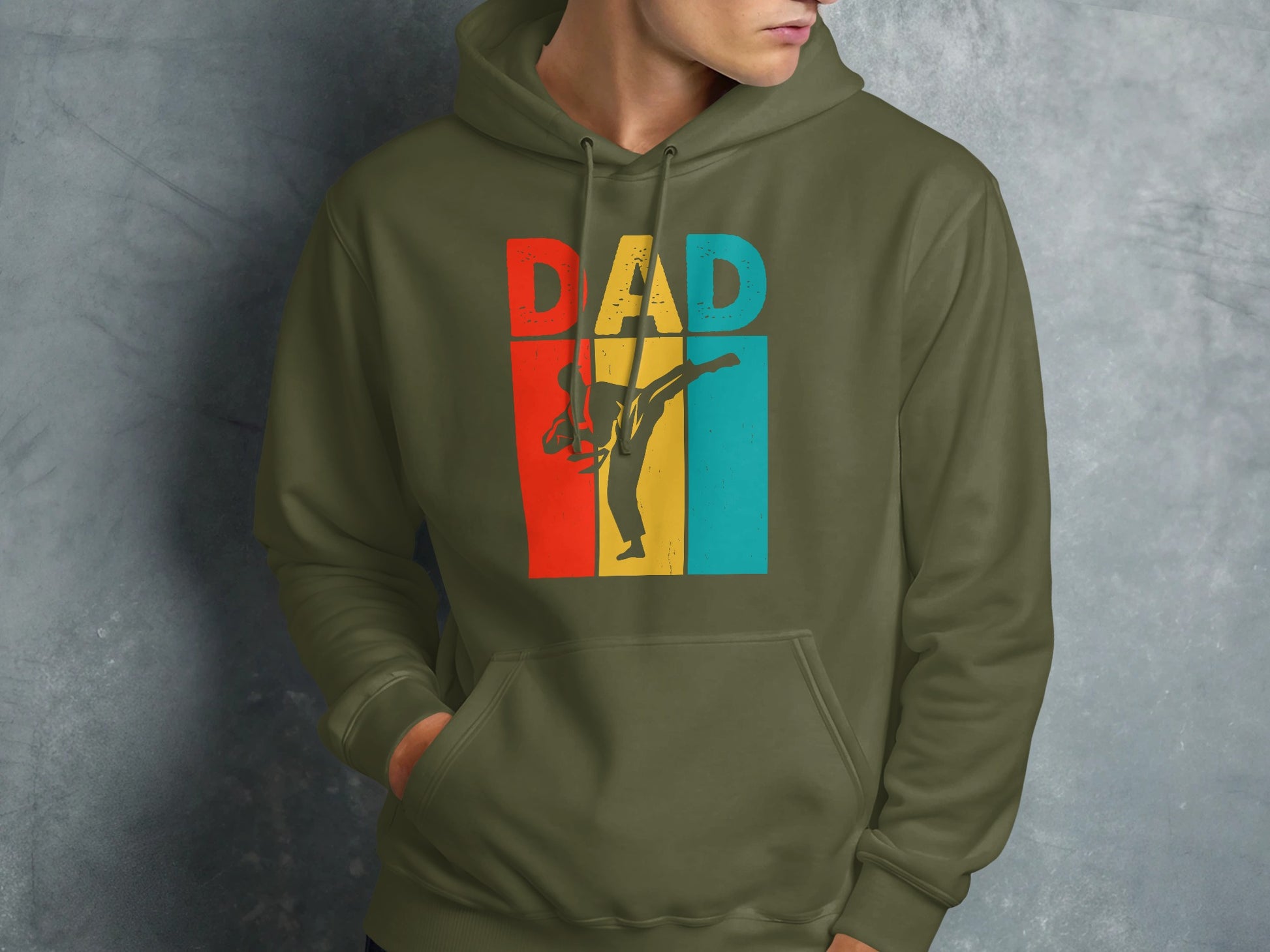 Green hoodie with "DAD" in retro colors and a silhouette of a martial artist.