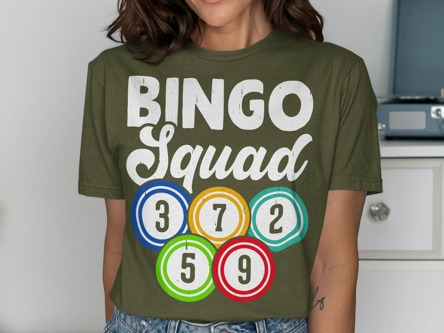 Olive green t-shirt with "BINGO Squad" and colorful bingo balls with numbers.