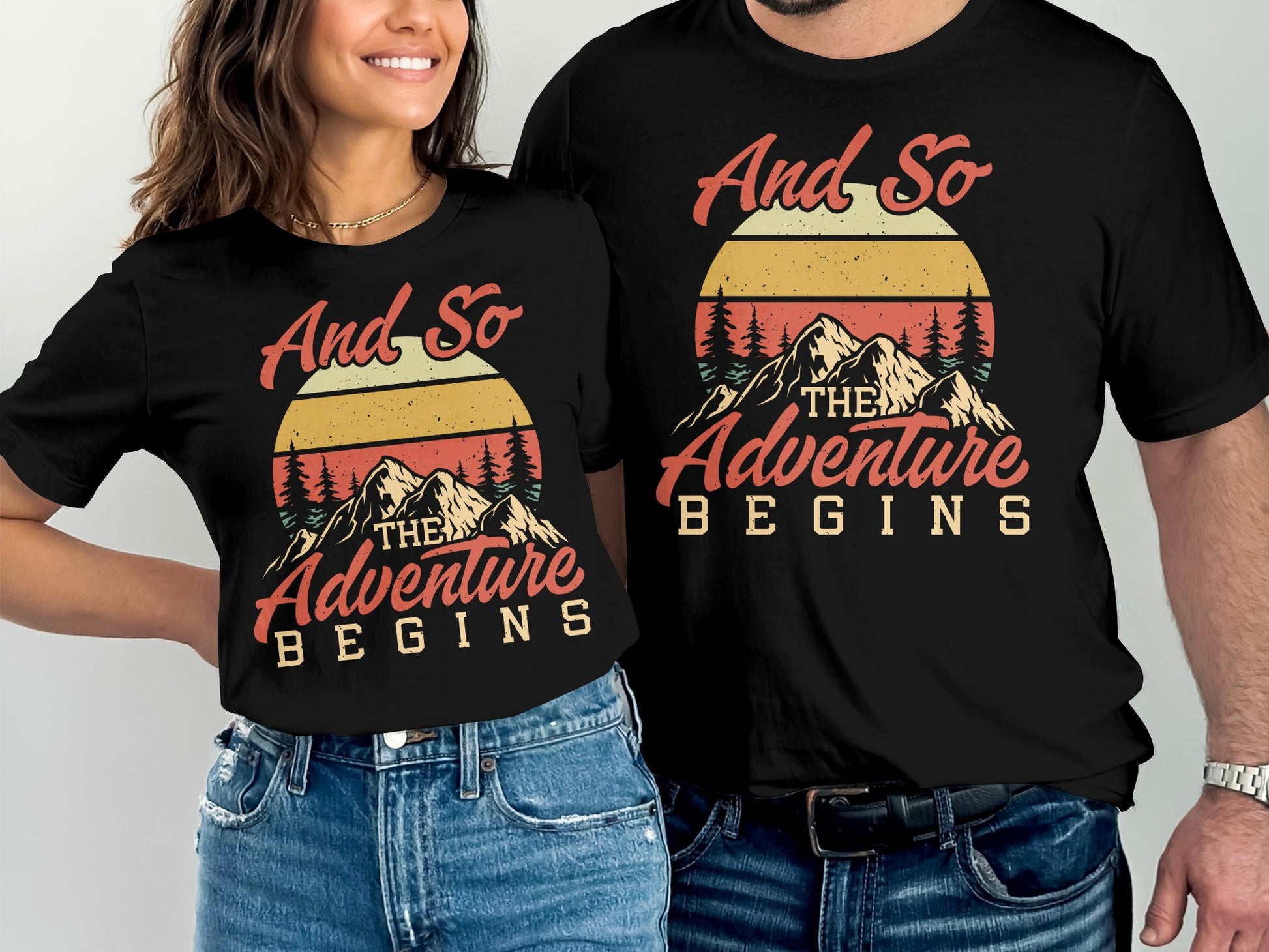 Couple wearing black t-shirts with "And So The Adventure Begins" sunset graphic.