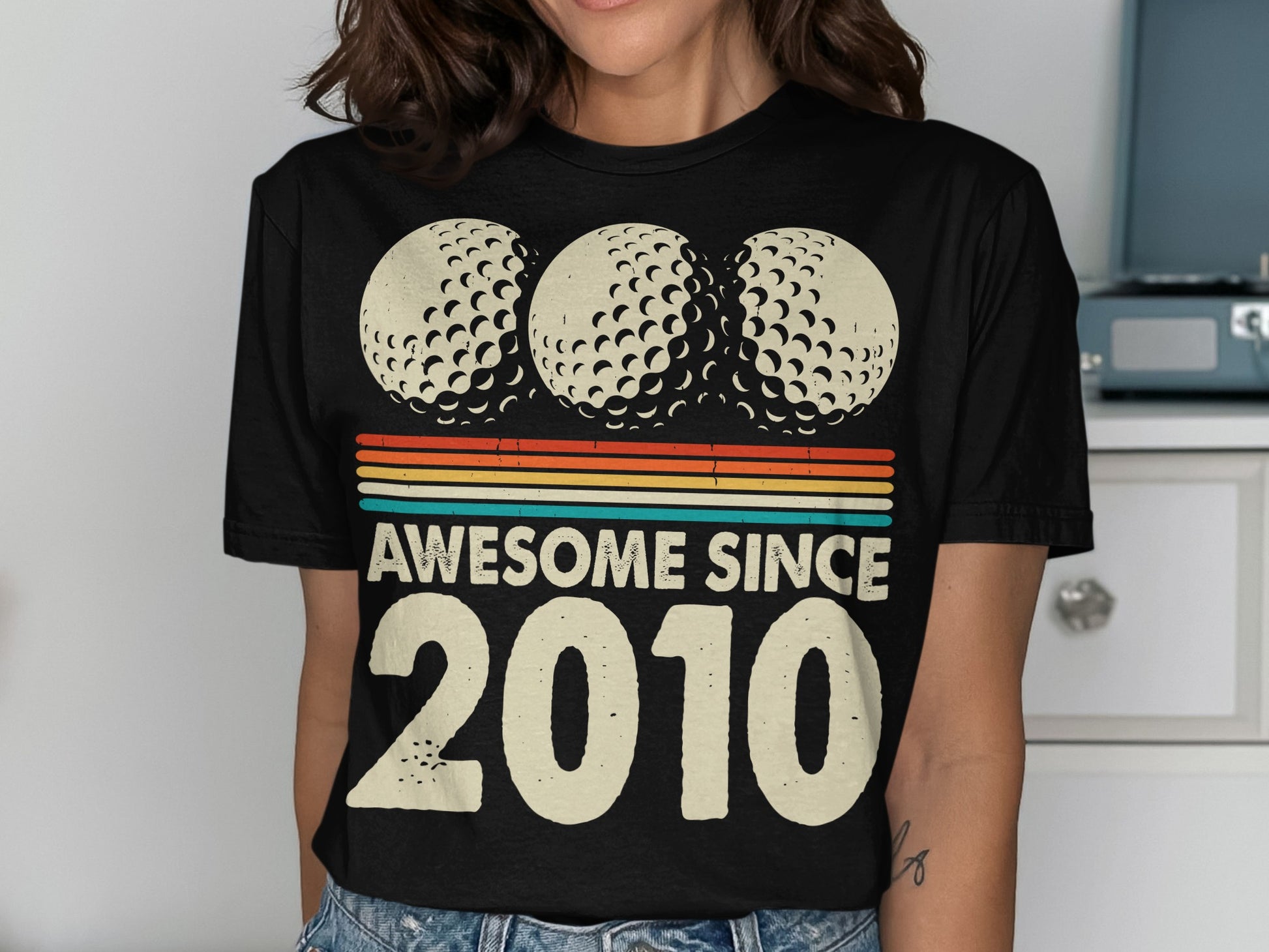Black t-shirt with three golf balls and "Awesome Since 2010" text.