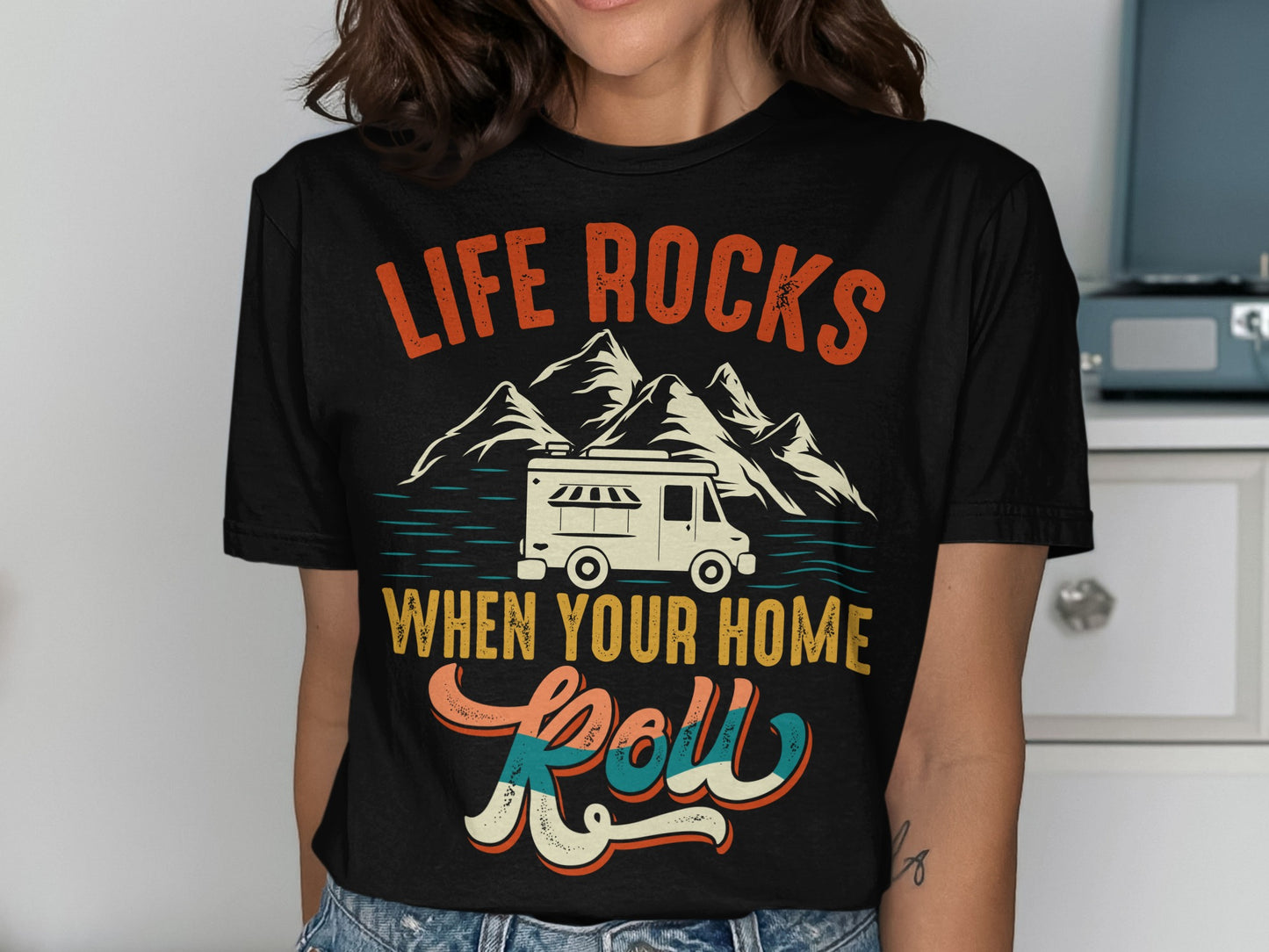 Black t-shirt with "LIFE ROCKS WHEN YOUR HOME Roll" text, mountains, and RV.