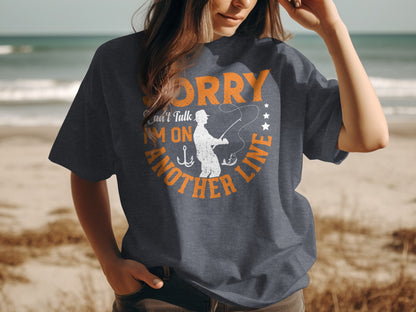 Dark grey t-shirt with "Sorry can't talk I'm on another line" fishing graphic.