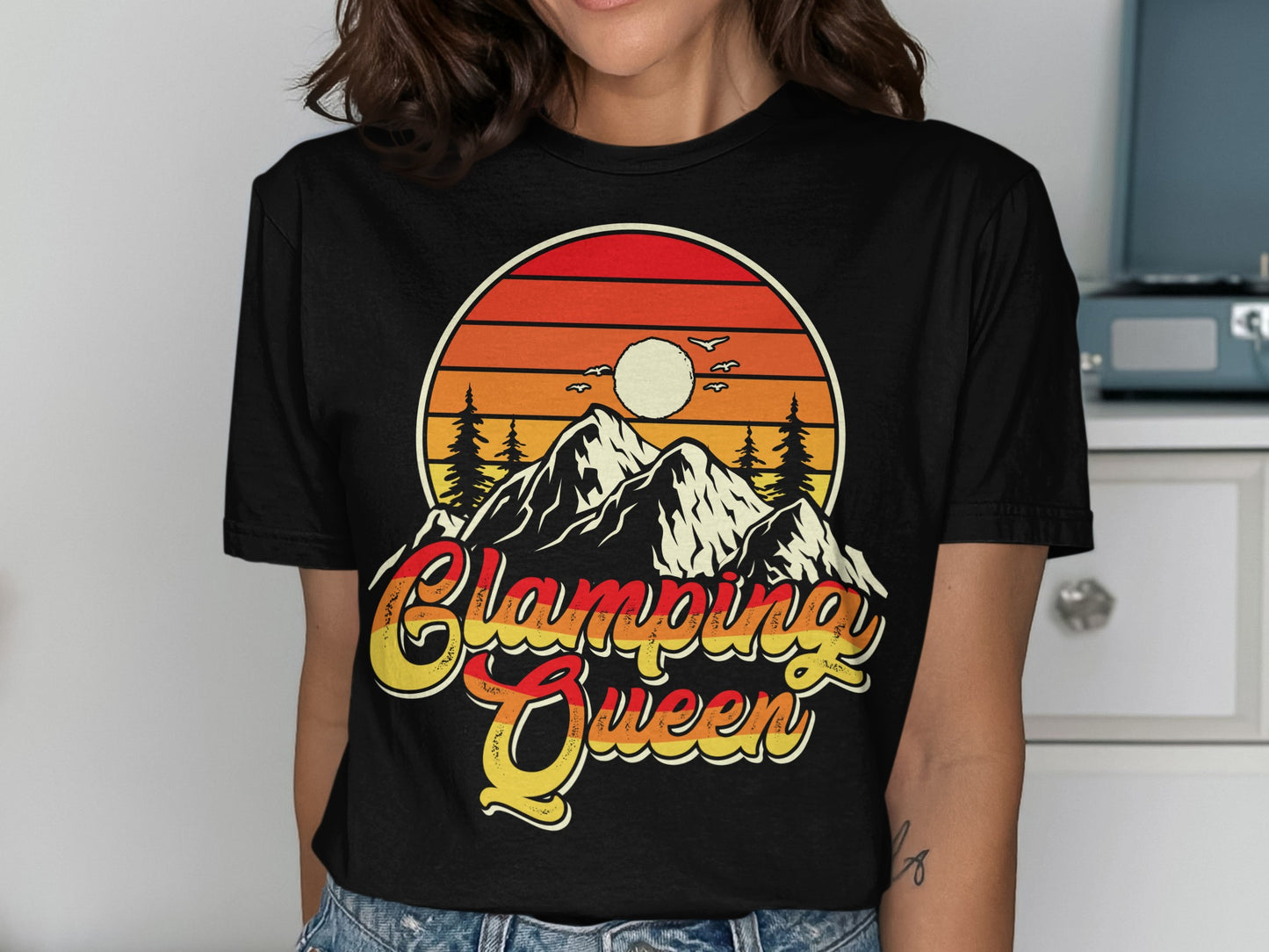 Sunset over mountains with "Glamping Queen" text on a t-shirt.