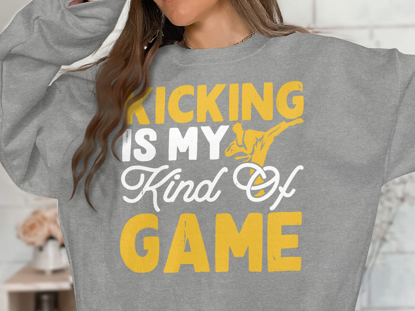 Grey sweatshirt with yellow text "KICKING IS MY Kind Of GAME" and karate silhouette.