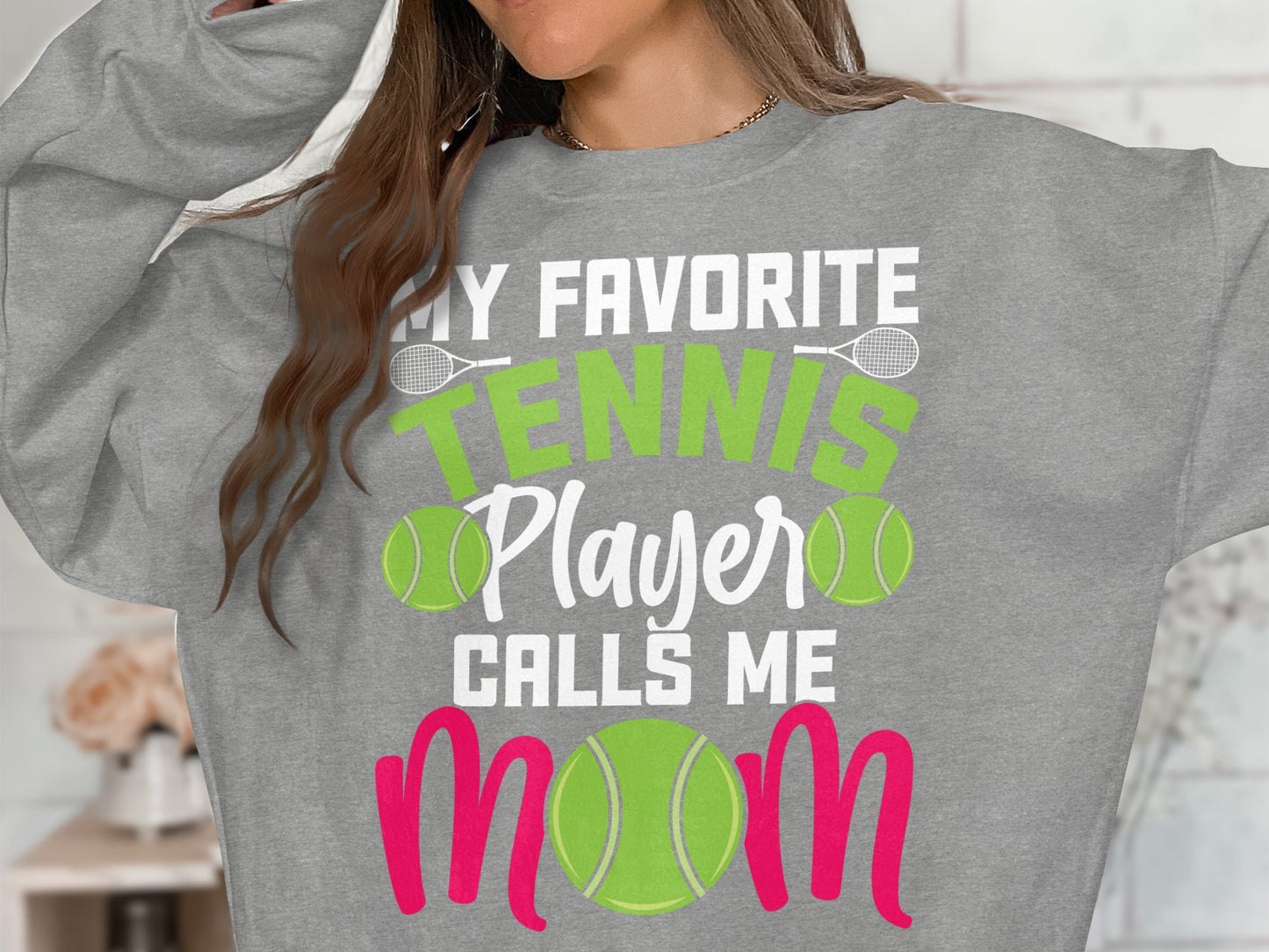 Gray sweatshirt with "My Favorite Tennis Player Calls Me Mom" in green and pink.