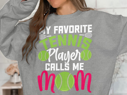 Gray sweatshirt with "My Favorite Tennis Player Calls Me Mom" in green and pink.