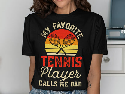 Black t-shirt with "MY FAVORITE TENNIS PLAYER CALLS ME DAD" graphic.