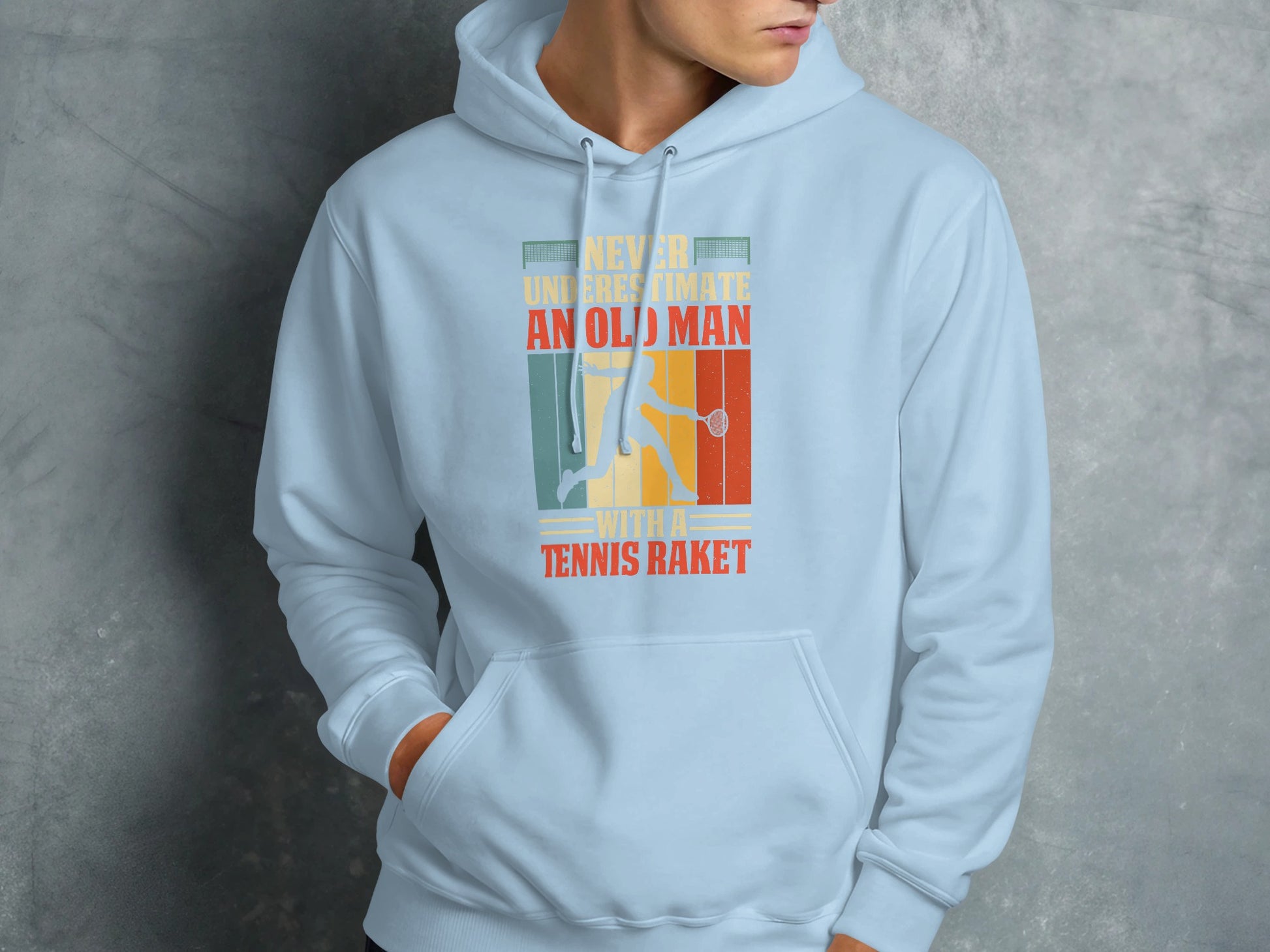 Light blue hoodie with "Never underestimate an old man with a tennis racket" text and tennis player graphic.