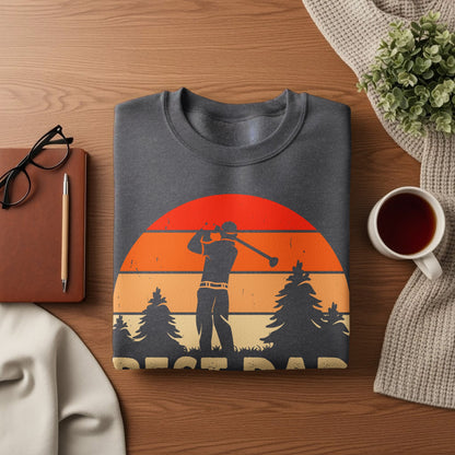 Graphic sweatshirt with golfer silhouette against a sunset and trees.