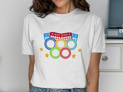 White t-shirt with bingo balls and Olympic rings graphic.