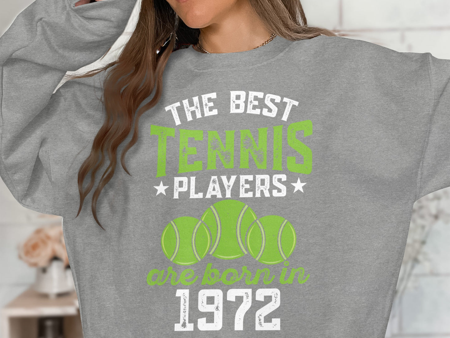 Grey sweatshirt with "The Best Tennis Players Are Born In 1972" and tennis balls.