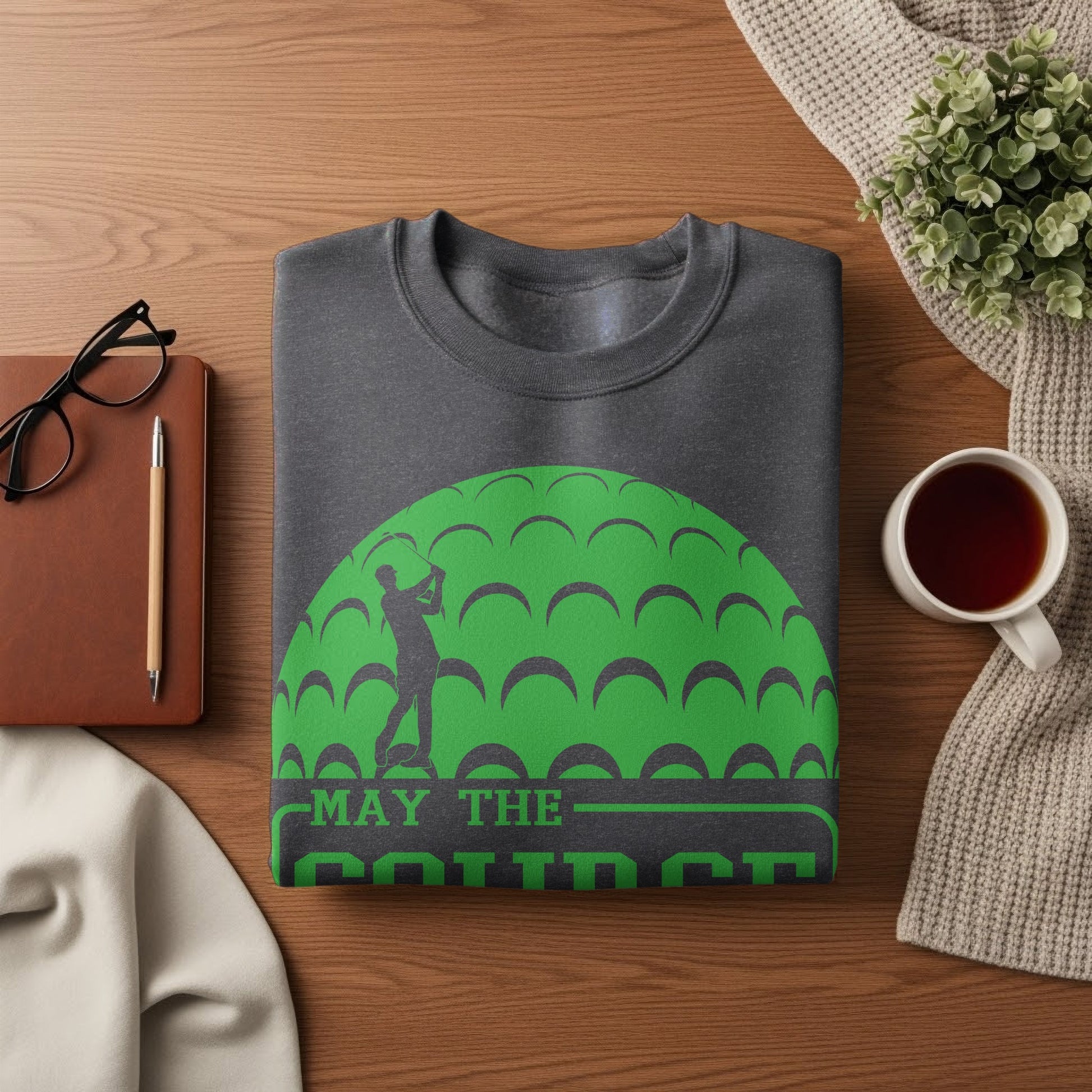 Dark gray sweatshirt with green golf ball graphic and text "May the course".
