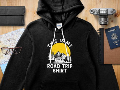 Black hoodie with "This is my Road Trip Shirt" text, mountains, and sun graphic.