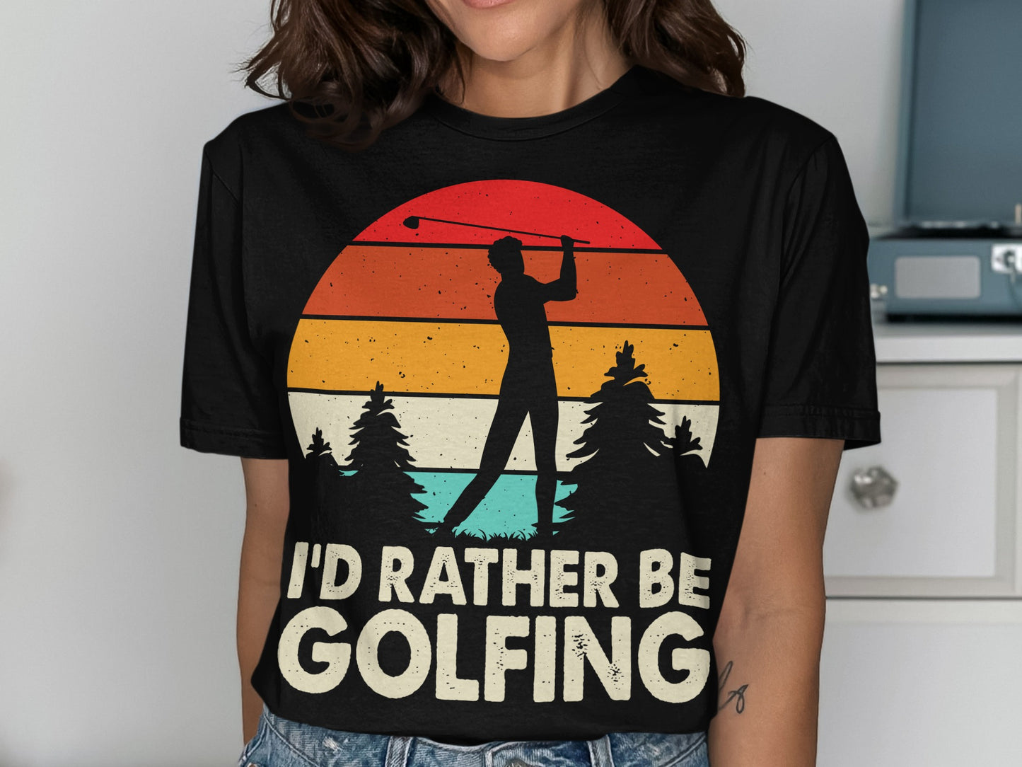 Black t-shirt with "I'd Rather Be Golfing" text and a golfer silhouette against a sunset.