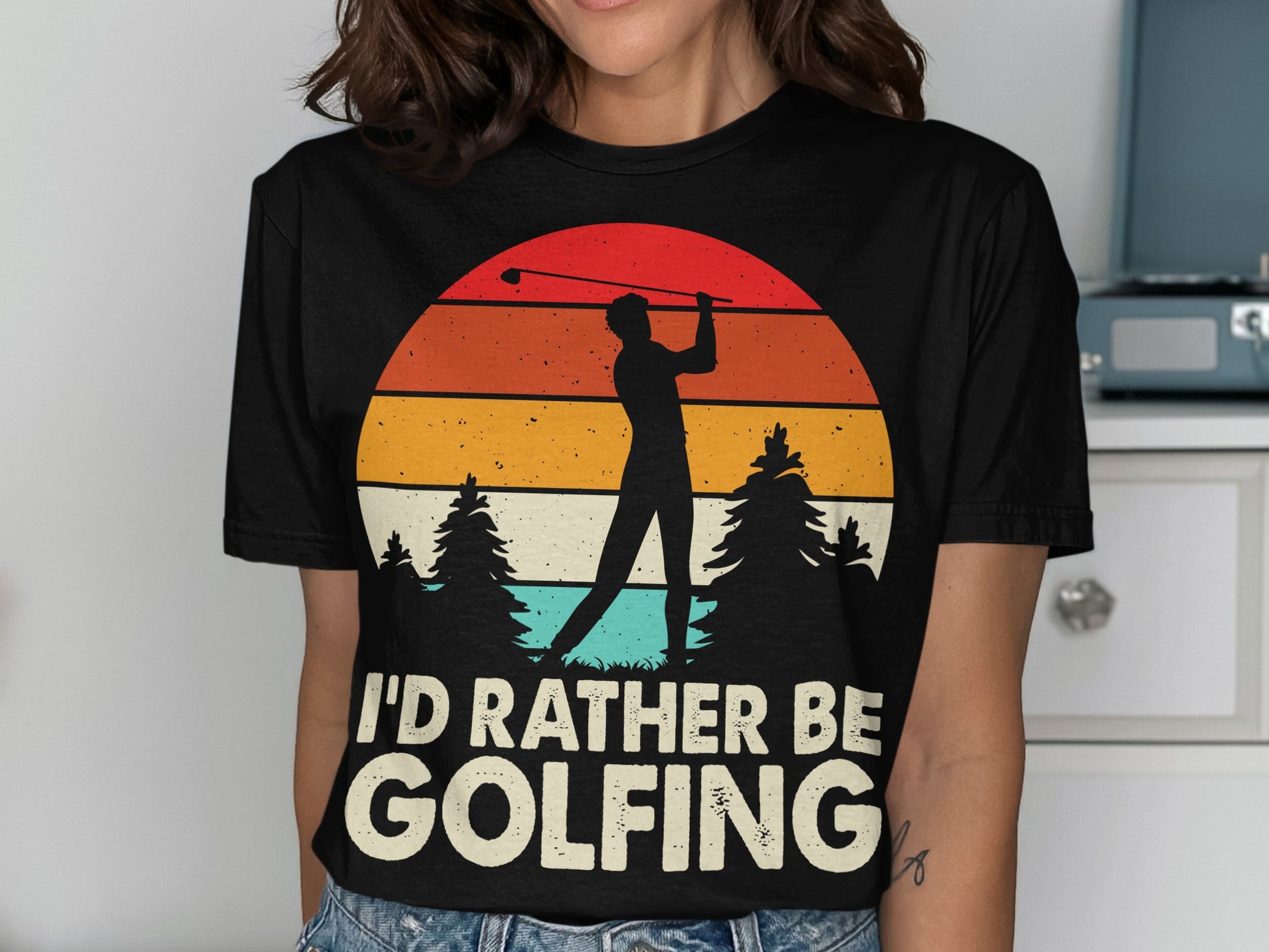 Black t-shirt with "I'd Rather Be Golfing" text and a golfer silhouette against a sunset.