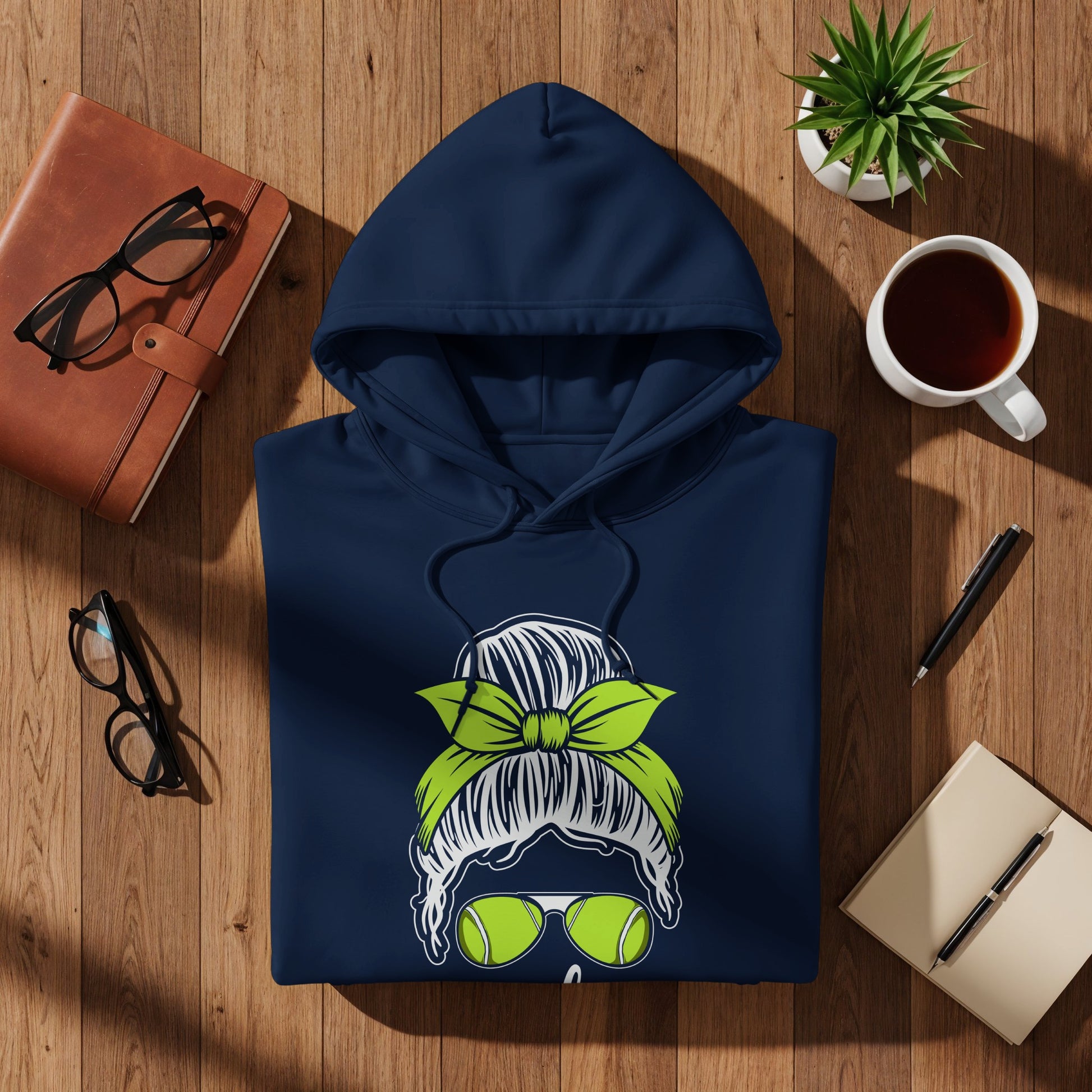 Navy hoodie with graphic of woman with messy bun, sunglasses, and tennis ball.
