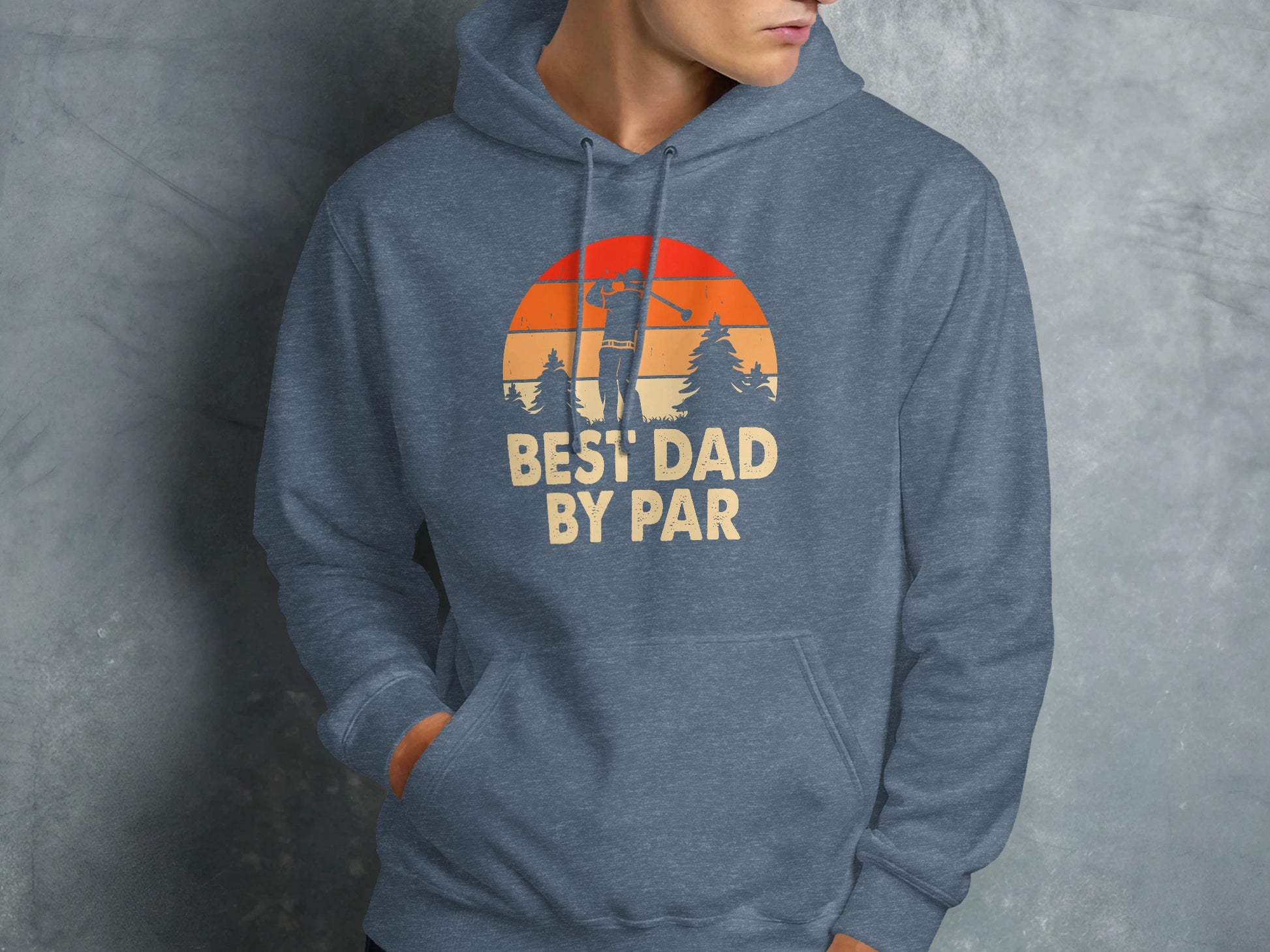 Graphic hoodie with "BEST DAD BY PAR" text and golf sunset design.
