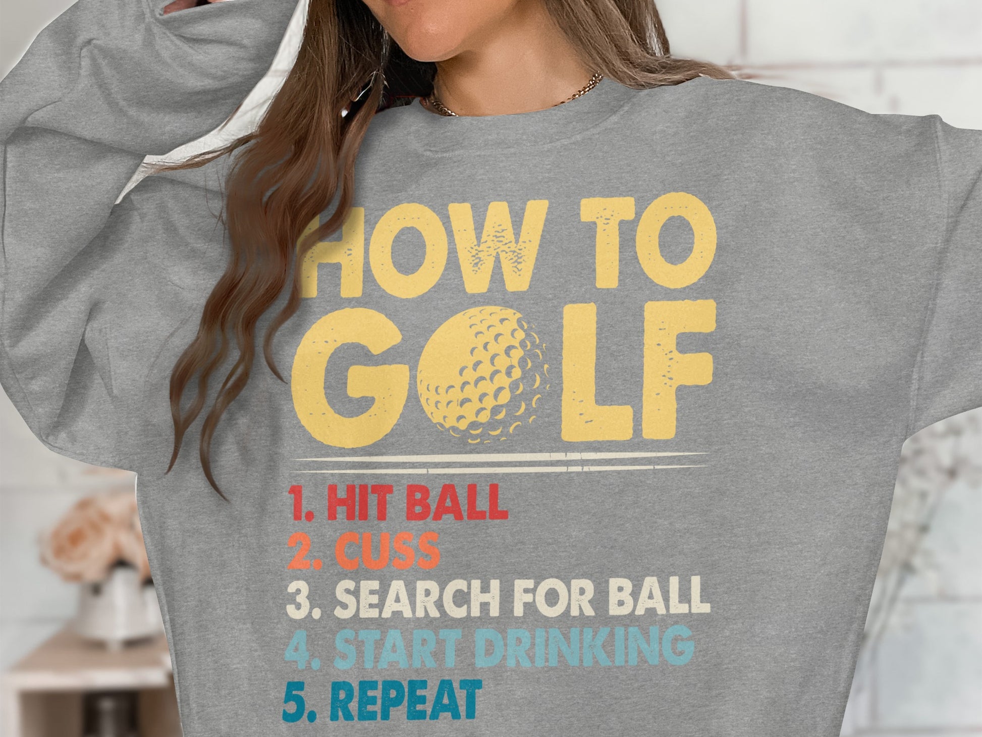 Grey sweatshirt with "HOW TO GOLF" and numbered instructions.