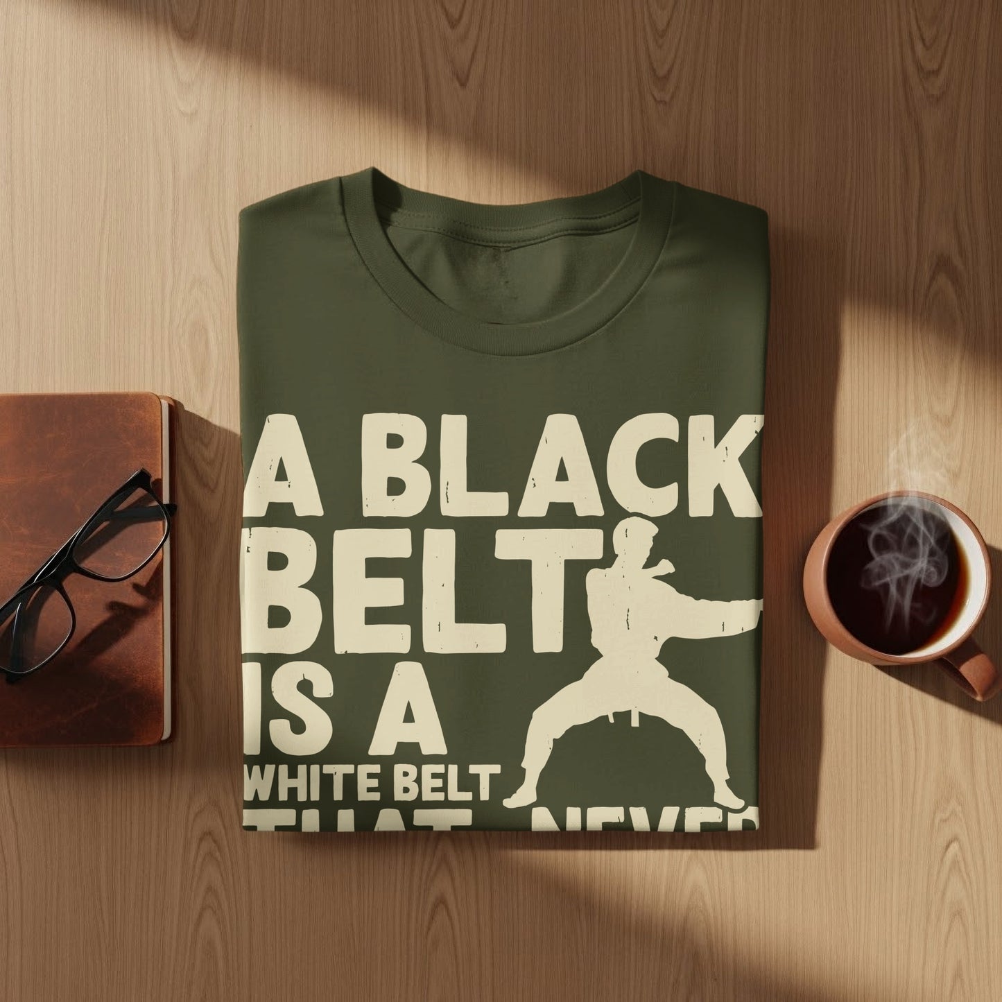 Green t-shirt with "A black belt is a white belt that never quit" text and karate graphic.