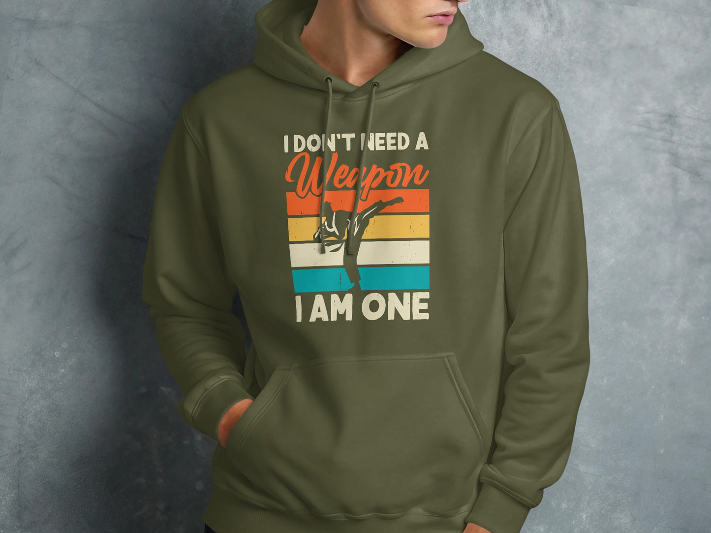 Green hoodie with text "I don't need a weapon I am one" and martial artist graphic.