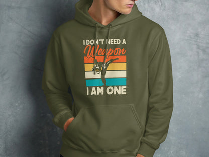 Green hoodie with text "I don't need a weapon I am one" and martial artist graphic.
