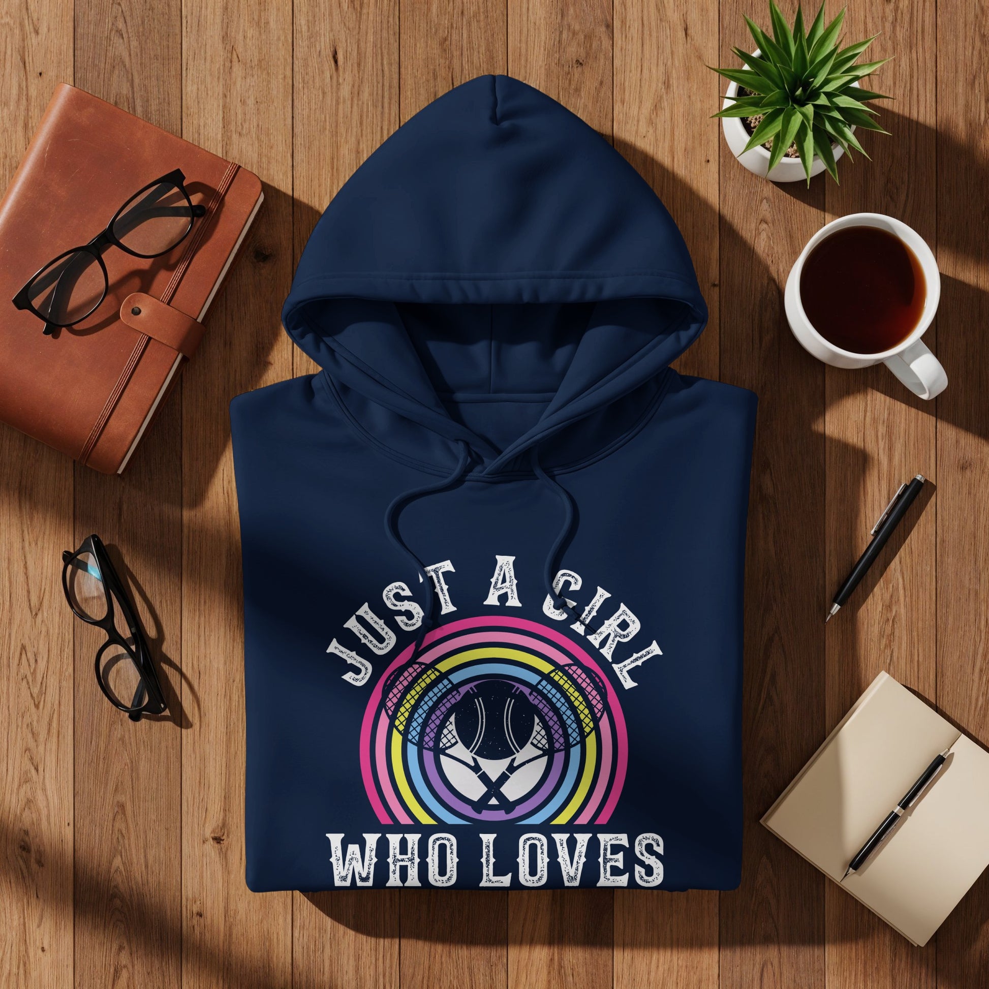 Navy hoodie with "Just a girl who loves" text and colorful tennis racket graphic.
