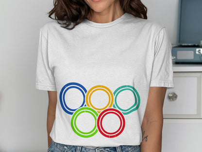 White t-shirt featuring the Olympic rings in blue, yellow, black, green, and red.