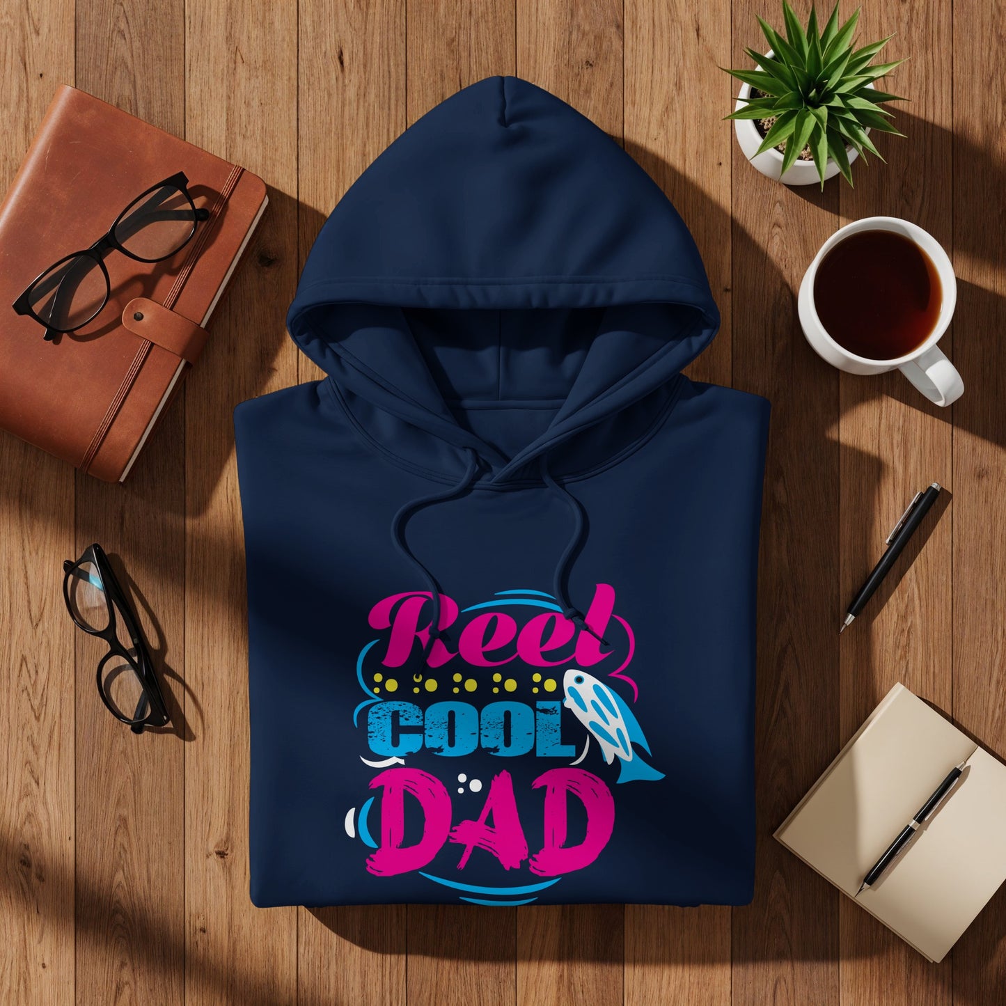 Navy hoodie with "Reel Cool Dad" text in colorful bubble letters.