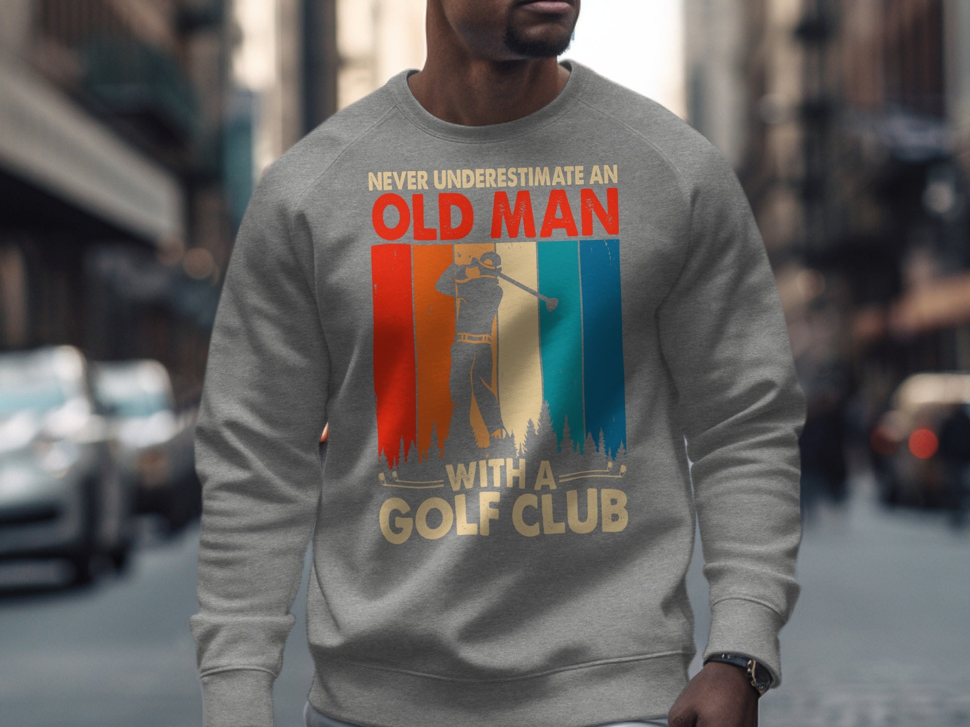 Gray sweatshirt with "Never Underestimate An Old Man With A Golf Club" text and golfer graphic.