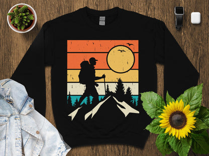 Black graphic sweatshirt featuring a vintage sunset mountain hiking scene.