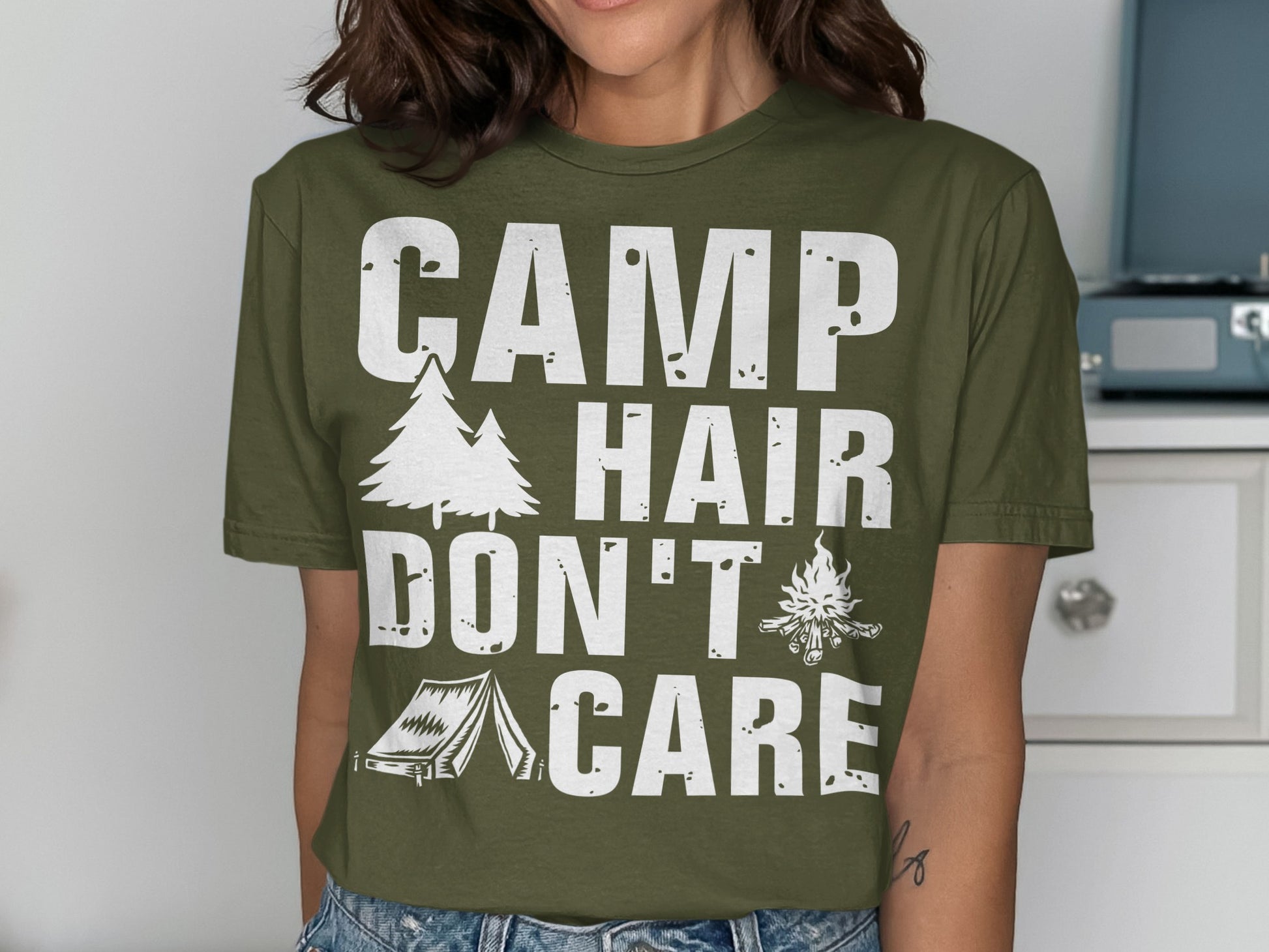 Olive green t-shirt with "CAMP HAIR DON'T CARE" text and camping graphics.