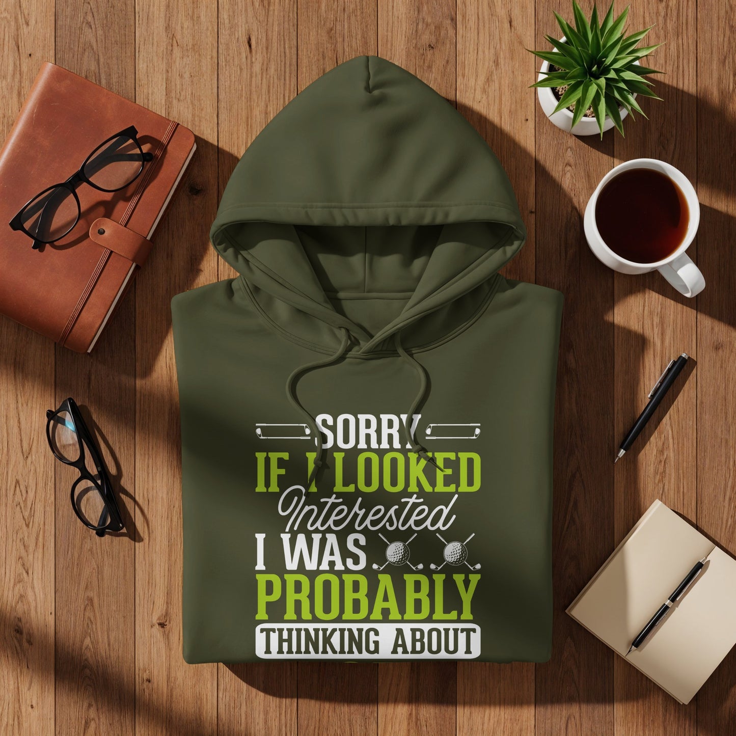 Olive green hoodie with "SORRY IF I LOOKED INTERESTED I WAS PROBABLY THINKING ABOUT GOLF" text.