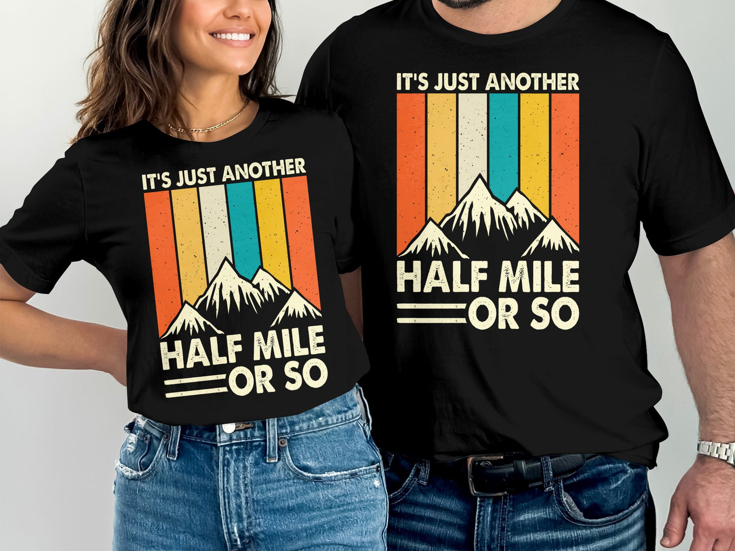 Couple wearing matching t-shirts with mountain and sunset design.