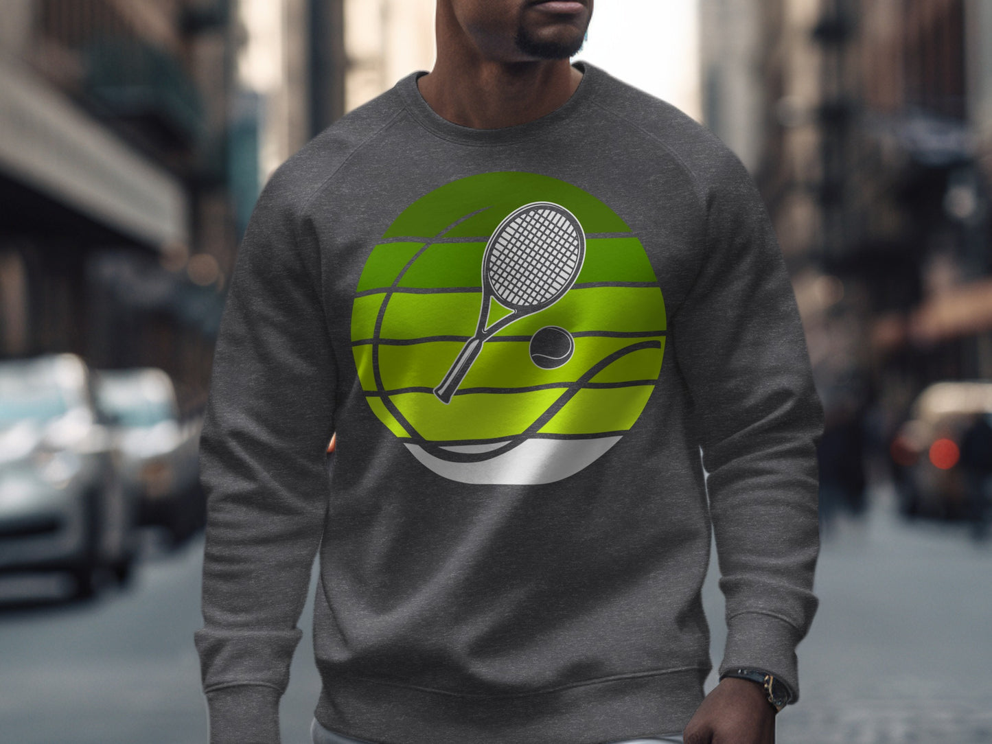 Man wearing a gray sweatshirt with a tennis racket and ball graphic.
