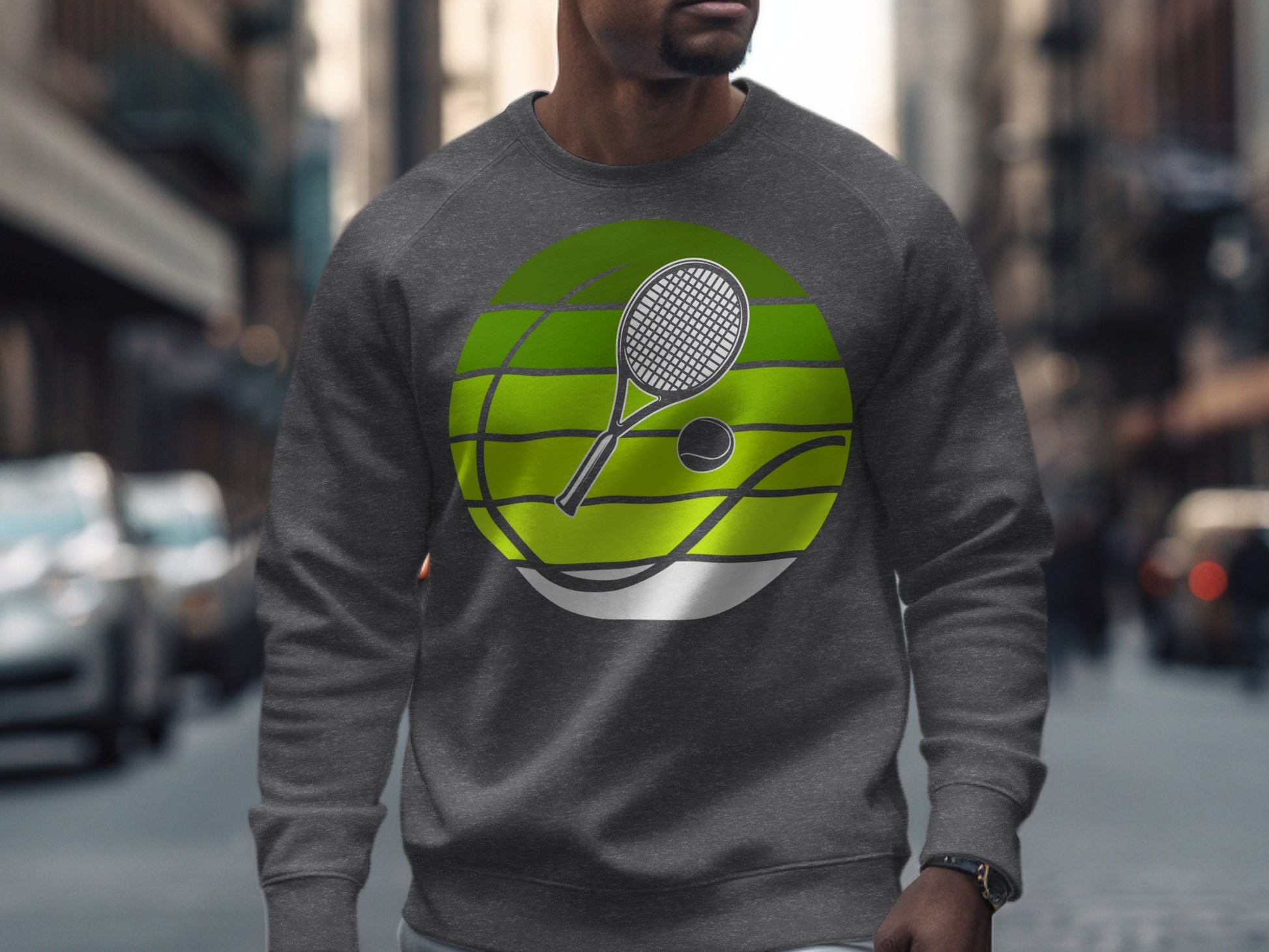 Man wearing a gray sweatshirt with a tennis racket and ball graphic.