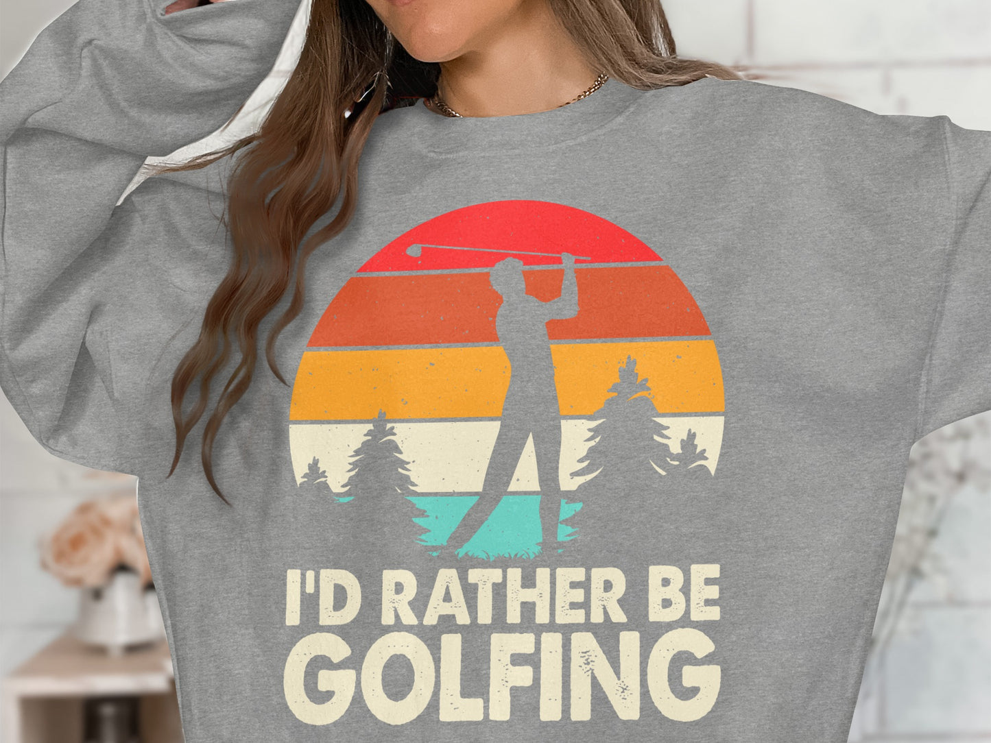 Gray sweatshirt with "I'D RATHER BE GOLFING" text and a sunset graphic.