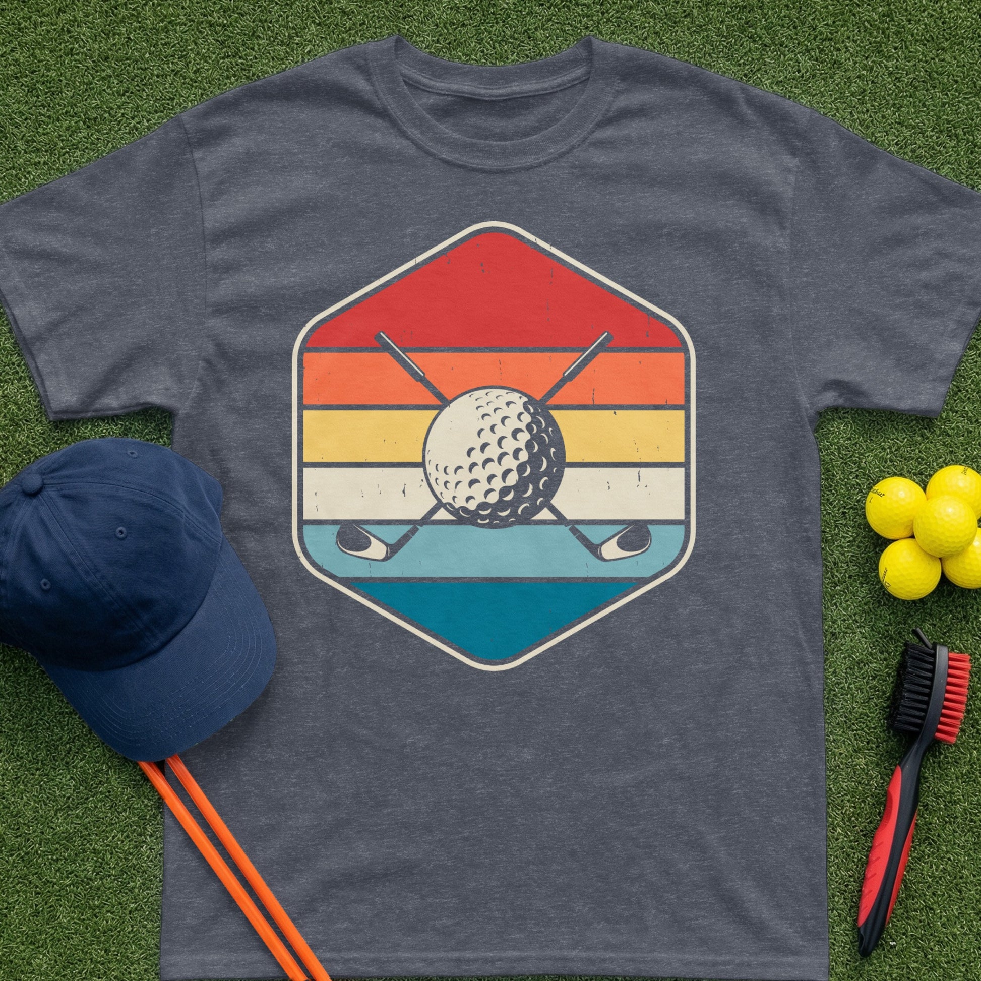 T-shirt graphic with golf ball, clubs, and retro stripes within a hexagon.
