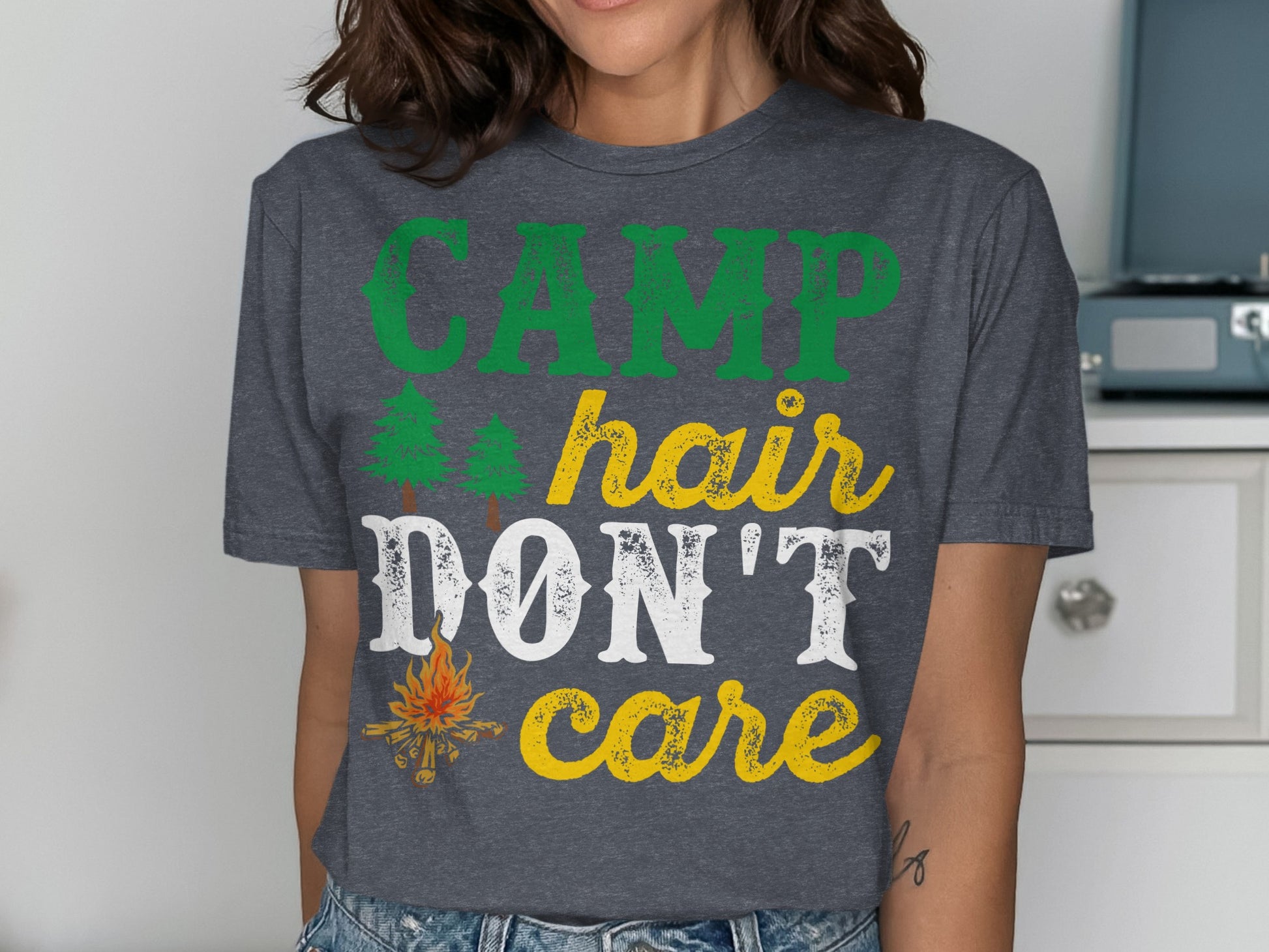 Dark grey t-shirt with "CAMP HAIR DON'T CARE" text and campfire graphic.