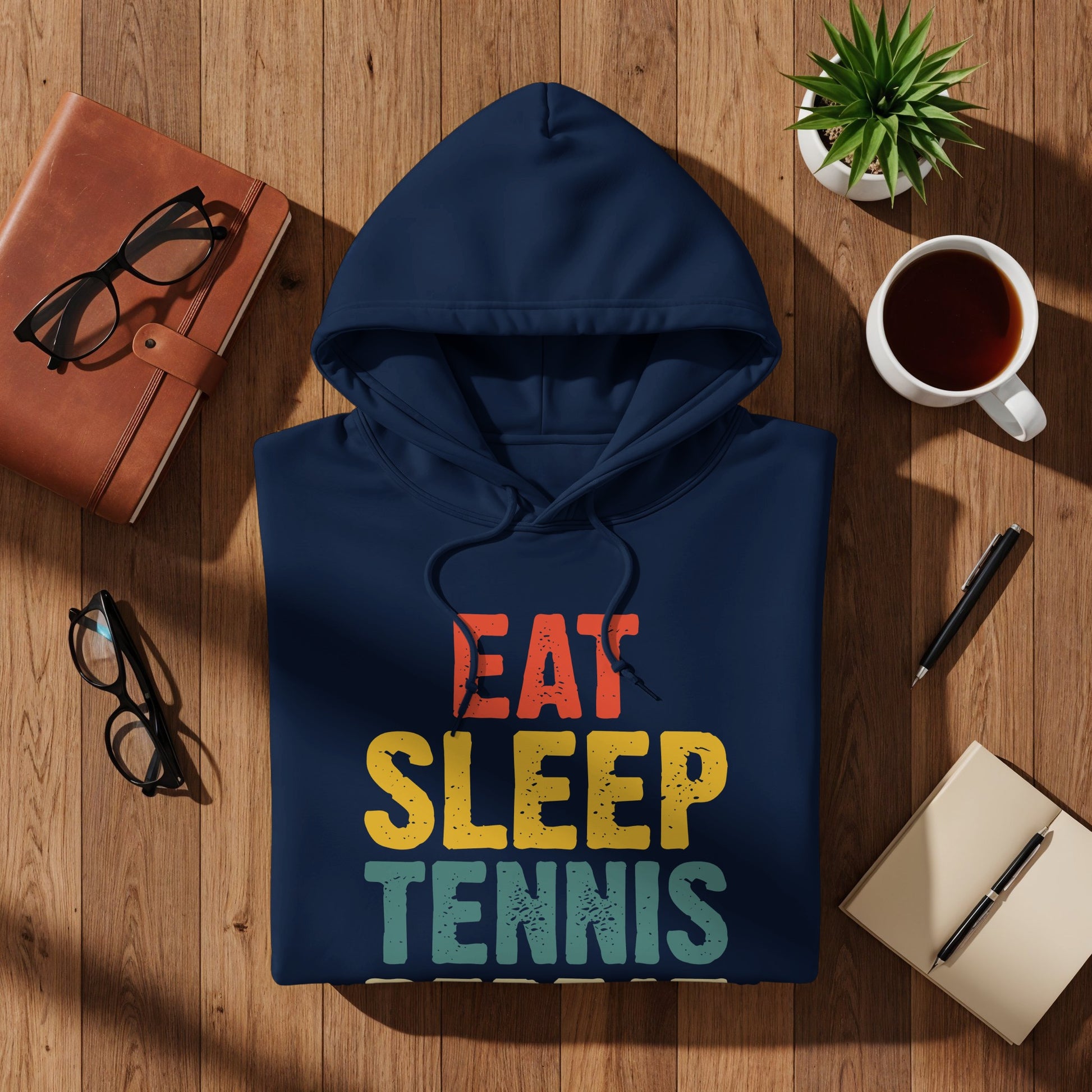 Navy blue hoodie with "EAT SLEEP TENNIS" in distressed red, yellow, and green lettering.