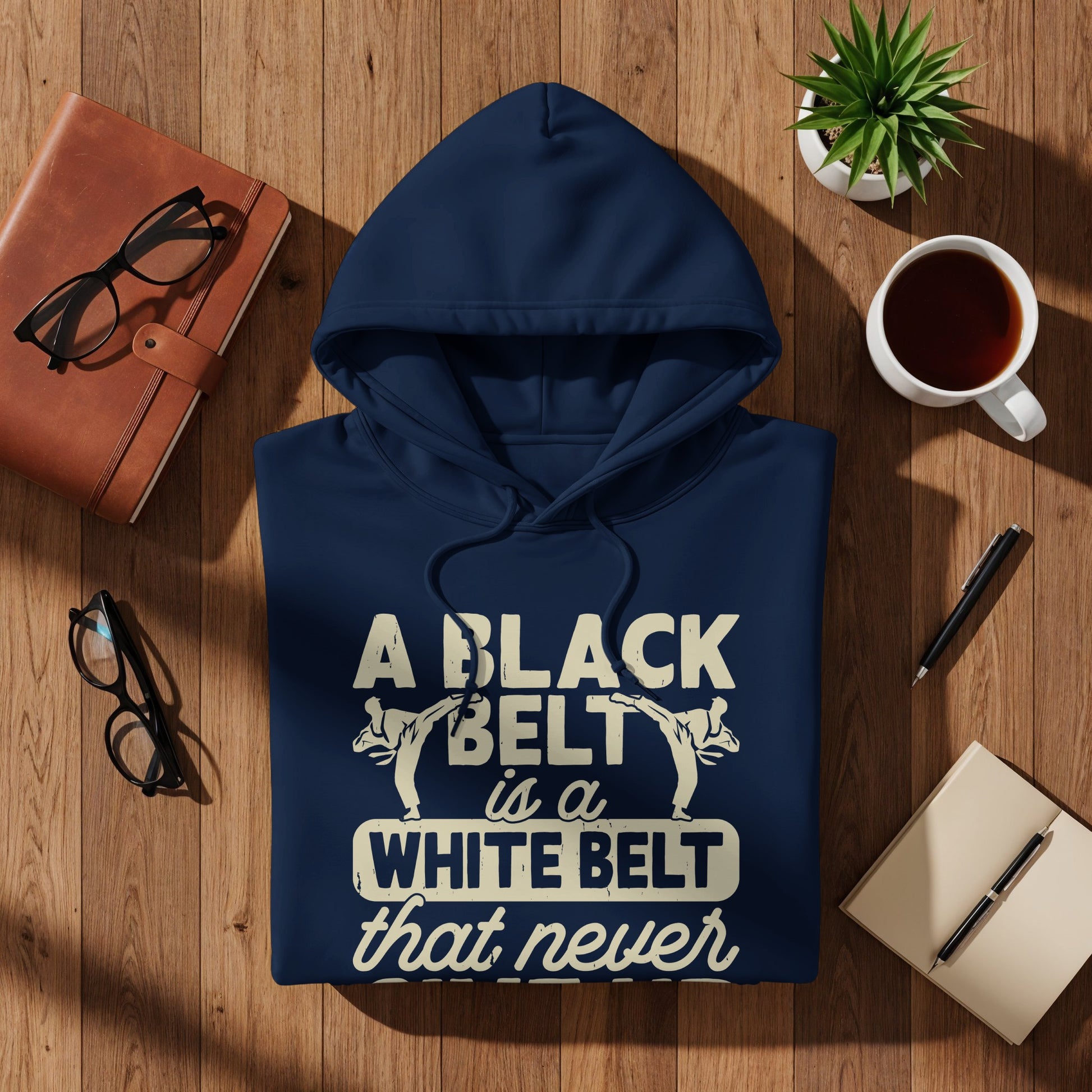 Navy blue hoodie with "A black belt is a white belt that never" text.