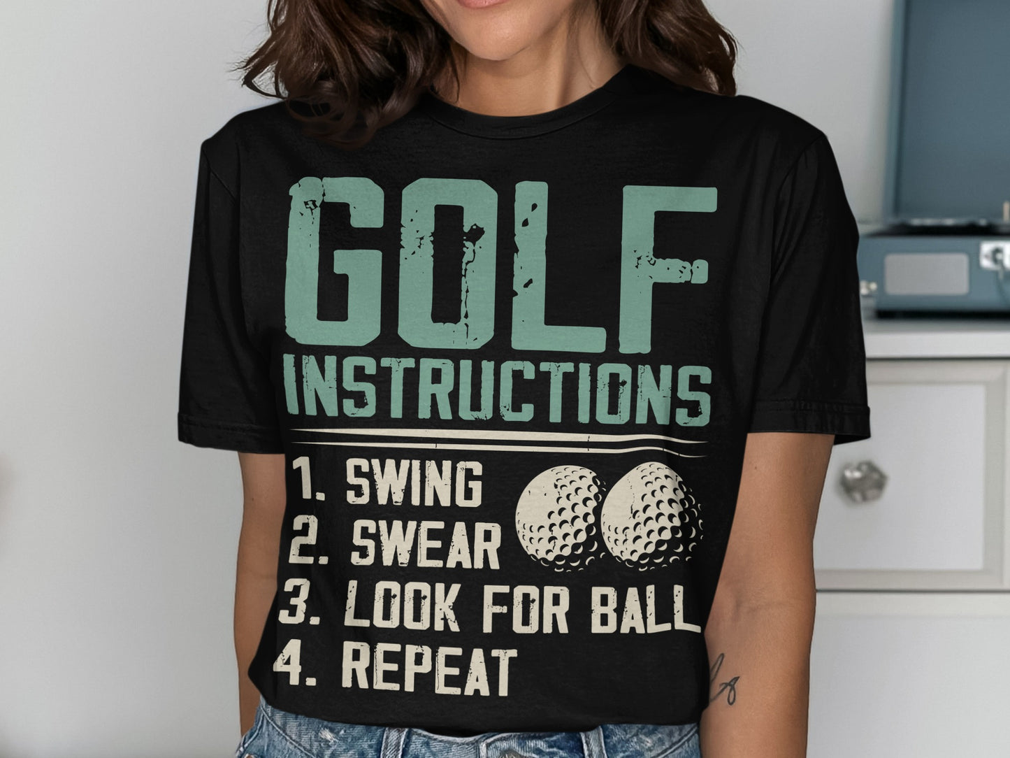 Black t-shirt with "GOLF INSTRUCTIONS" and numbered steps, featuring golf balls.