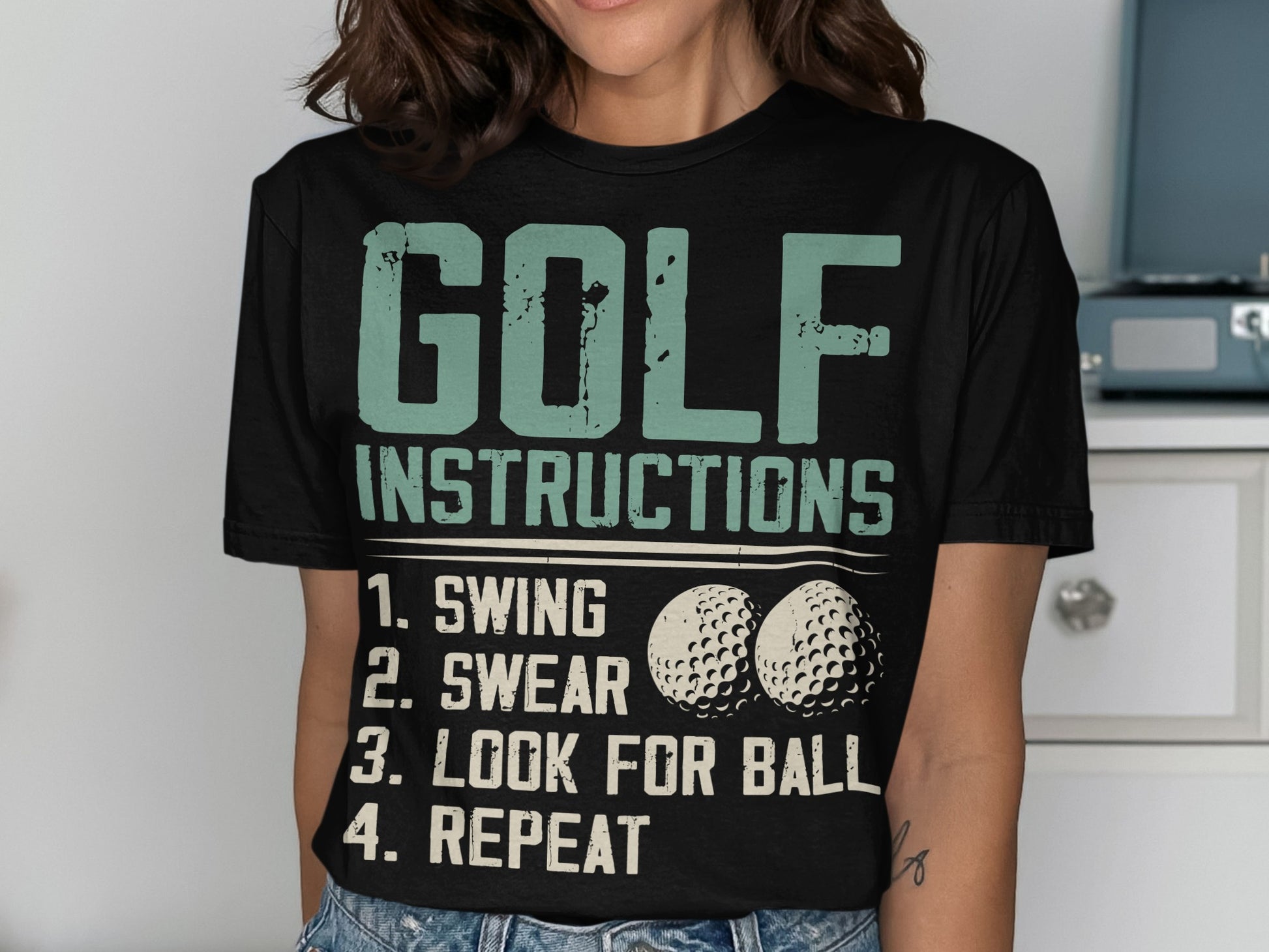 Black t-shirt with "GOLF INSTRUCTIONS" and numbered steps, featuring golf balls.