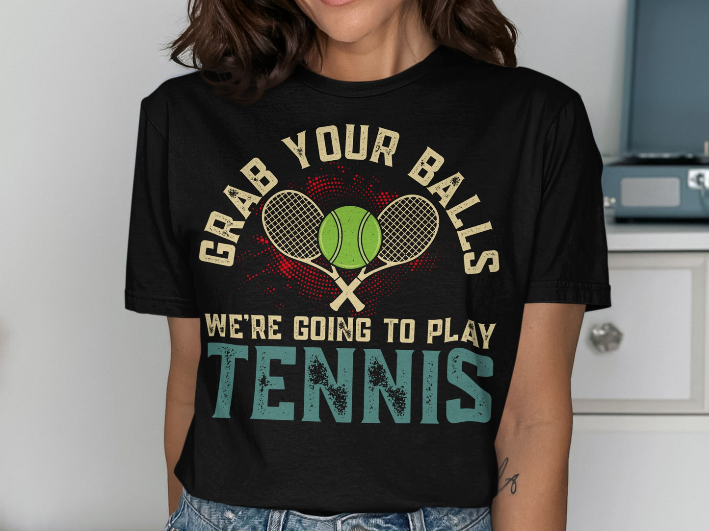 Black t-shirt with "GRAB YOUR BALLS WE'RE GOING TO PLAY TENNIS" and tennis rackets.