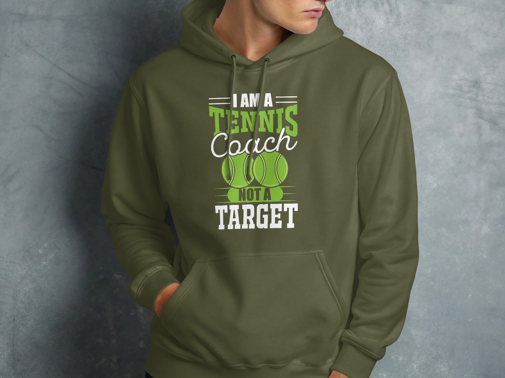 Olive green hoodie with "I Am A Tennis Coach Not A Target" text and tennis balls.